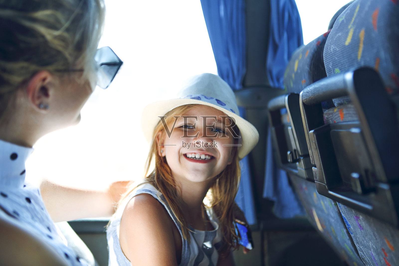 一个带着小女儿坐在公共汽车里的女人照片摄影图片