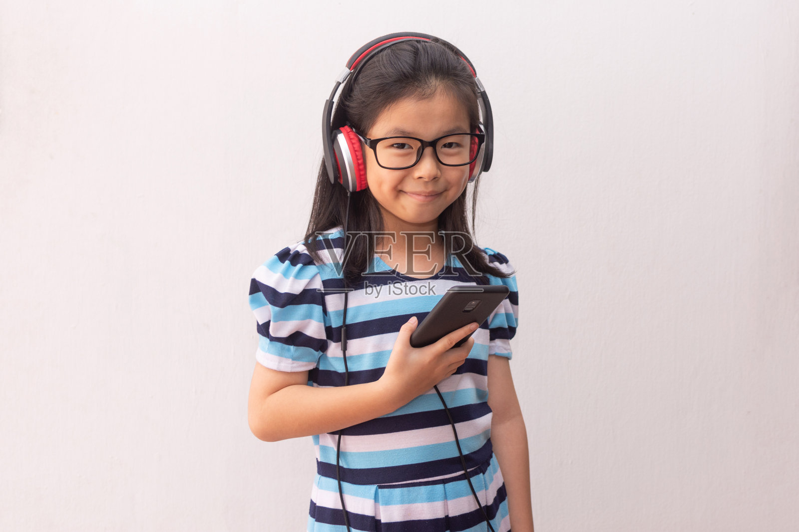 亚洲女孩戴着耳机听音乐照片摄影图片