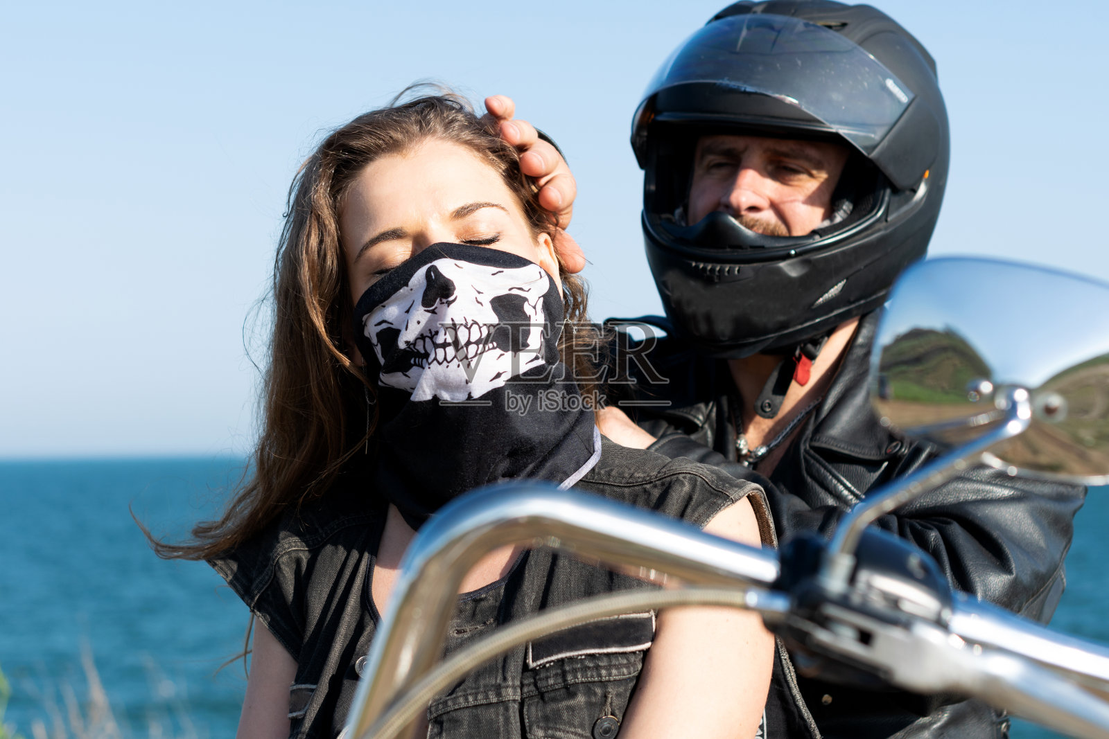 美丽的女孩在面具和她的男朋友在头盔的特写肖像。骑摩托车的人几照片摄影图片