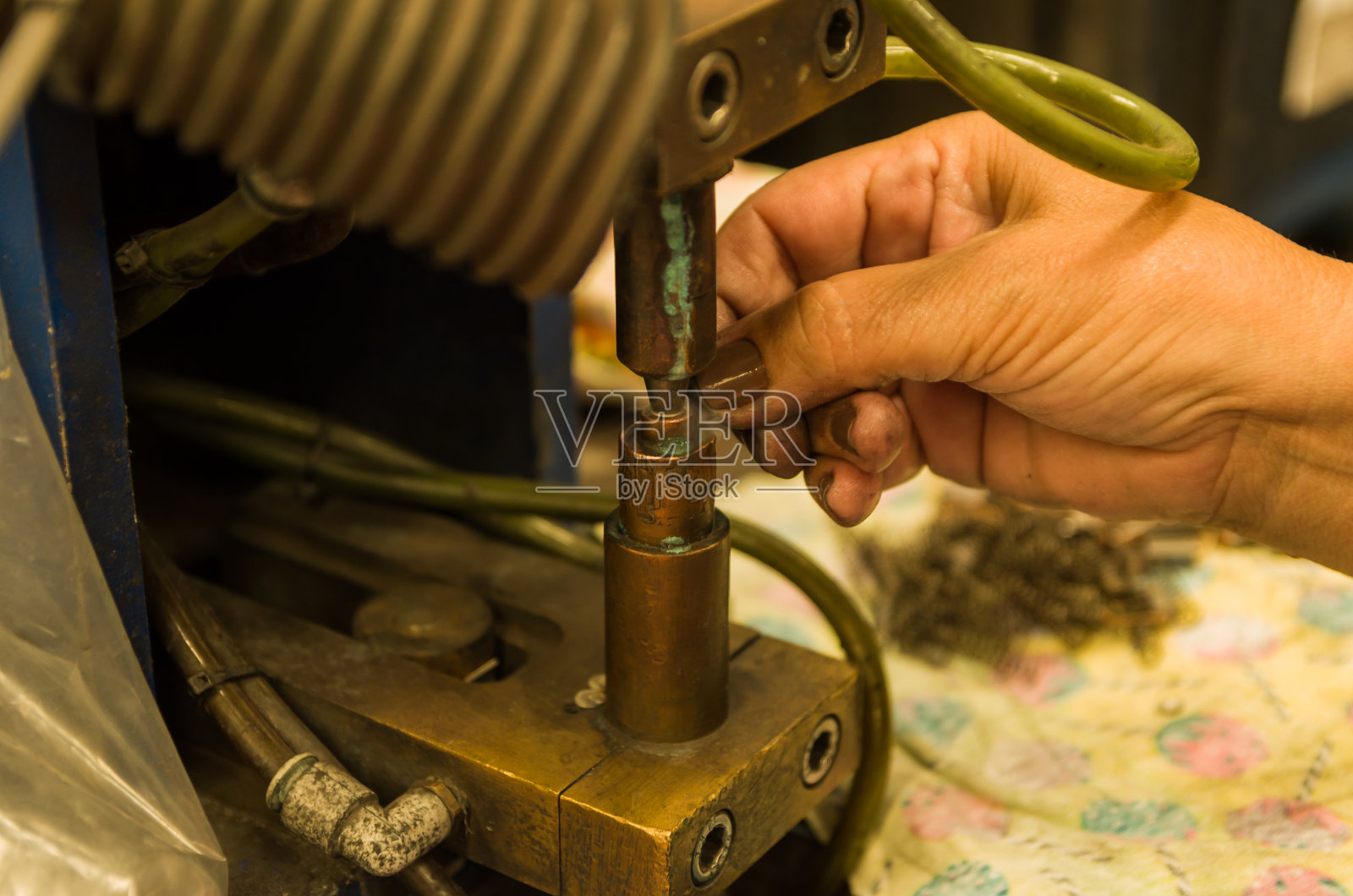 女人的手在焊接一个零件。照片摄影图片
