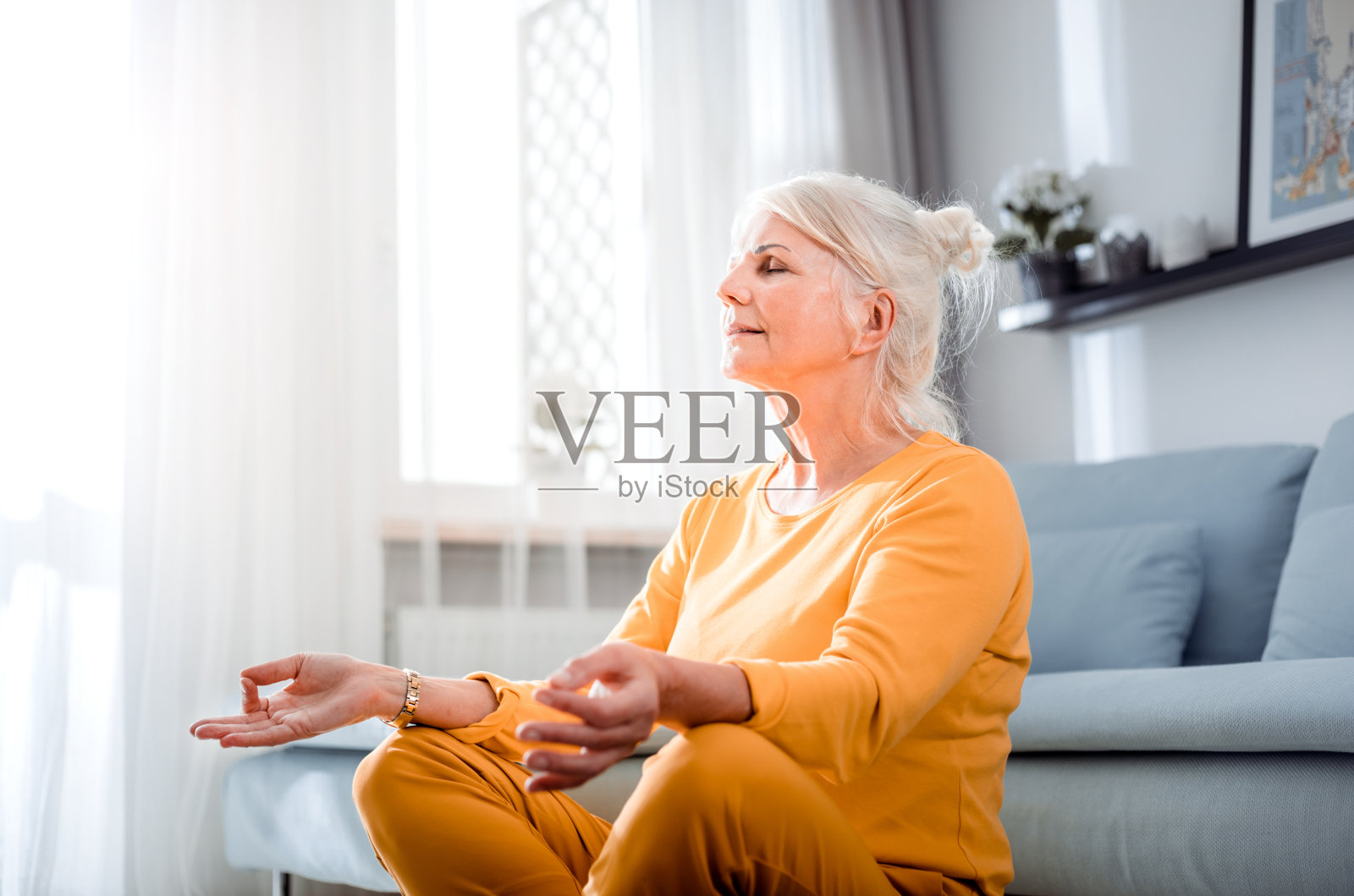 年长女性在莲花姿势冥想坐在地板上在家照片摄影图片