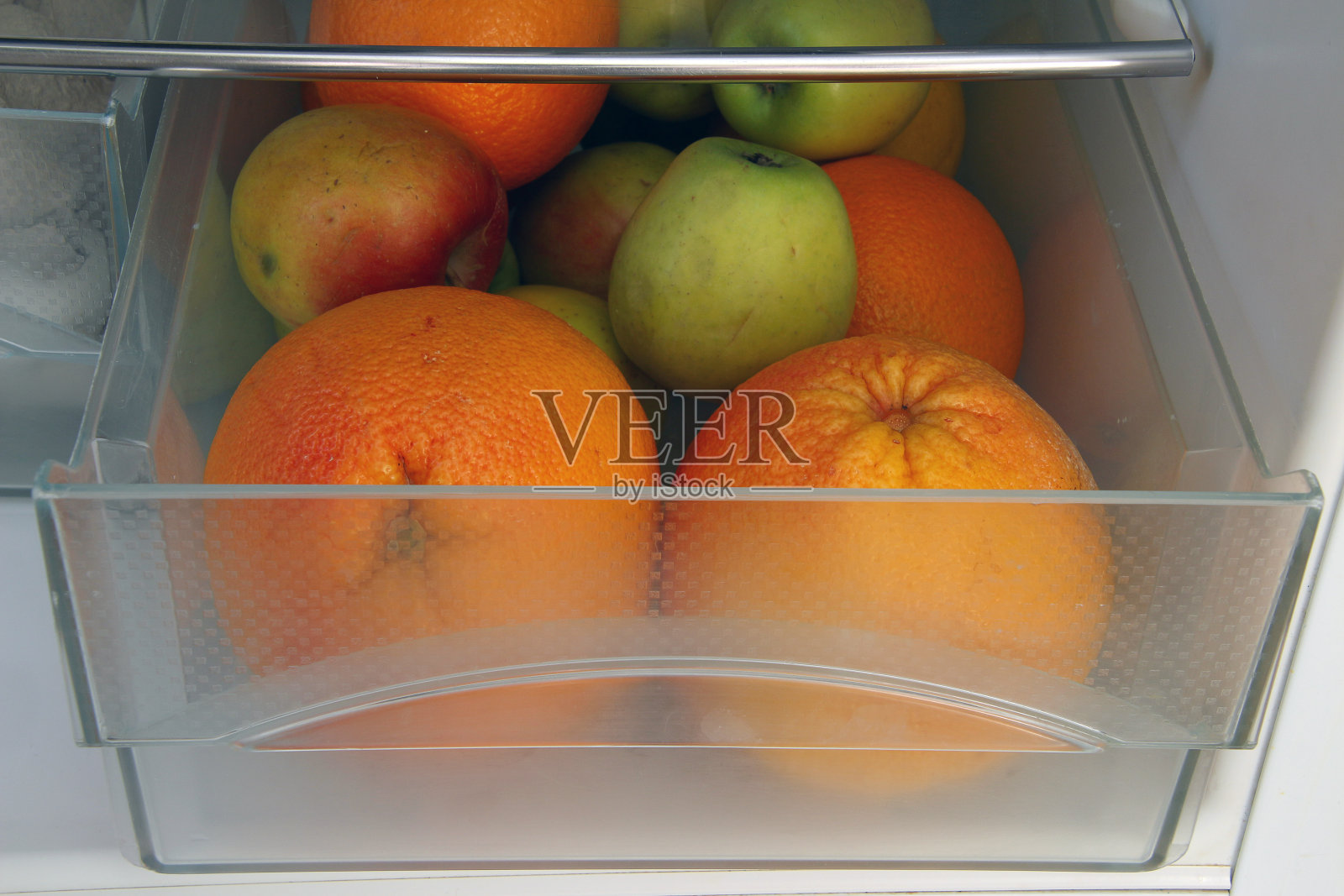 柑橘和苹果放在冰箱里照片摄影图片