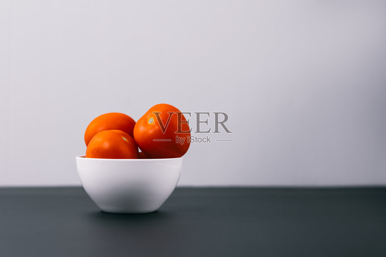 白碗里鲜亮多汁的西红柿。照片摄影图片