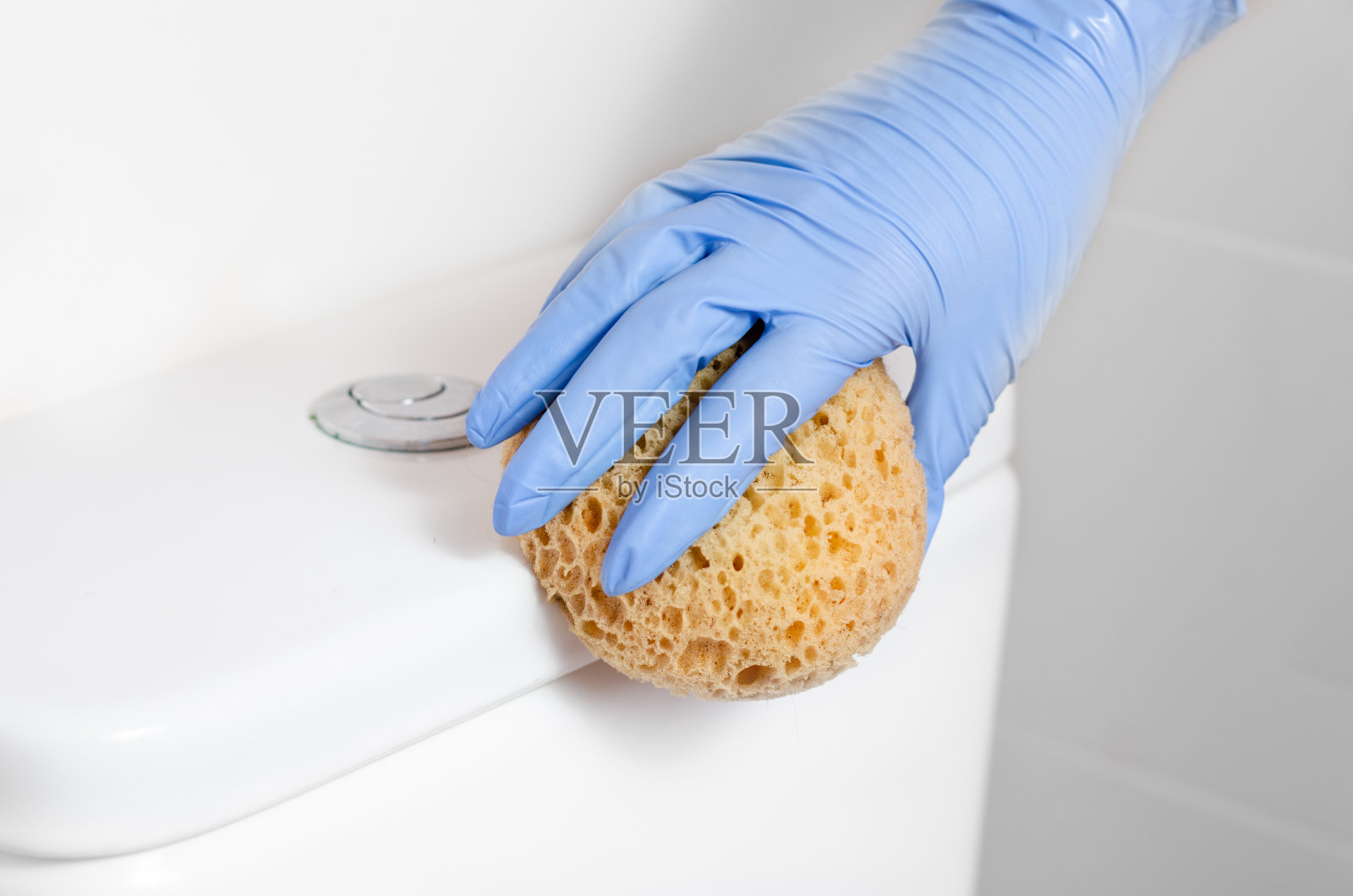 女佣带着手术手套用消毒湿巾清洁冲水马桶。细菌和冠状病毒传播的预防。照片摄影图片
