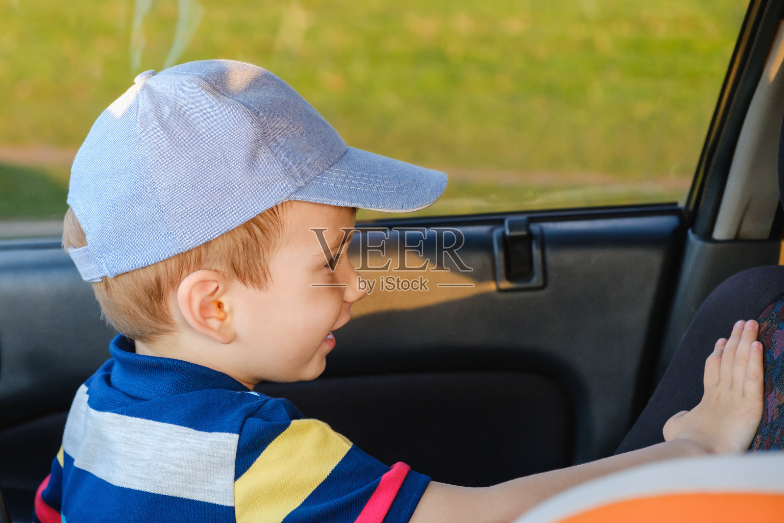 可爱的小男孩坐在车里的肖像。照片摄影图片