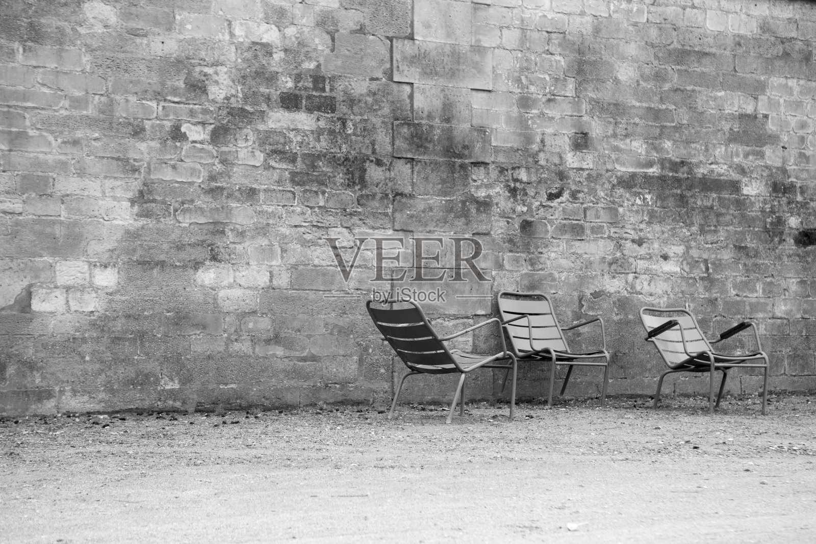 冬天的杜伊勒里宫花园，有石墙和三个空椅子照片摄影图片
