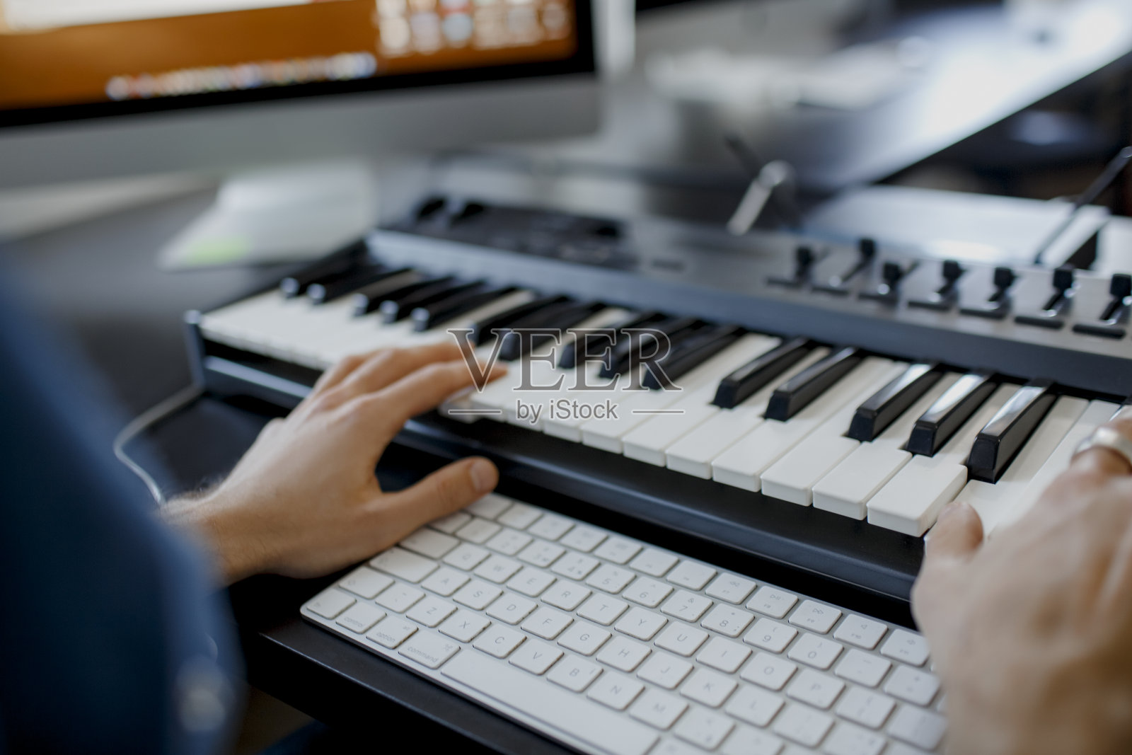 作曲家手在录音室钢琴键。音乐制作技术，人在钢琴和电脑键盘上工作。近距离的概念。照片摄影图片