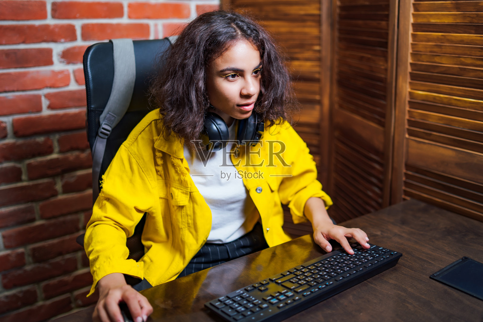 年轻漂亮的女人正坐在一个打开的笔记本电脑前。照片摄影图片