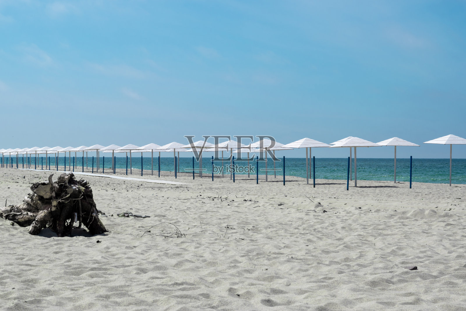 沙滩多沙，海边还有许多白色的沙滩伞在岸边照片摄影图片