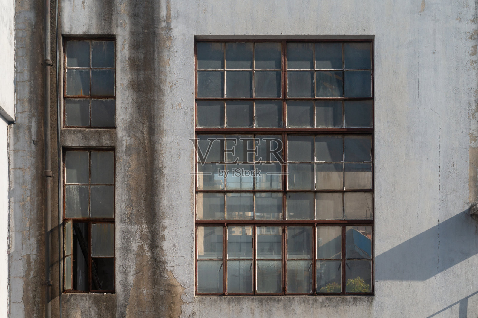 阳光明媚的日子里，废弃工厂或仓库的玻璃窗照片摄影图片