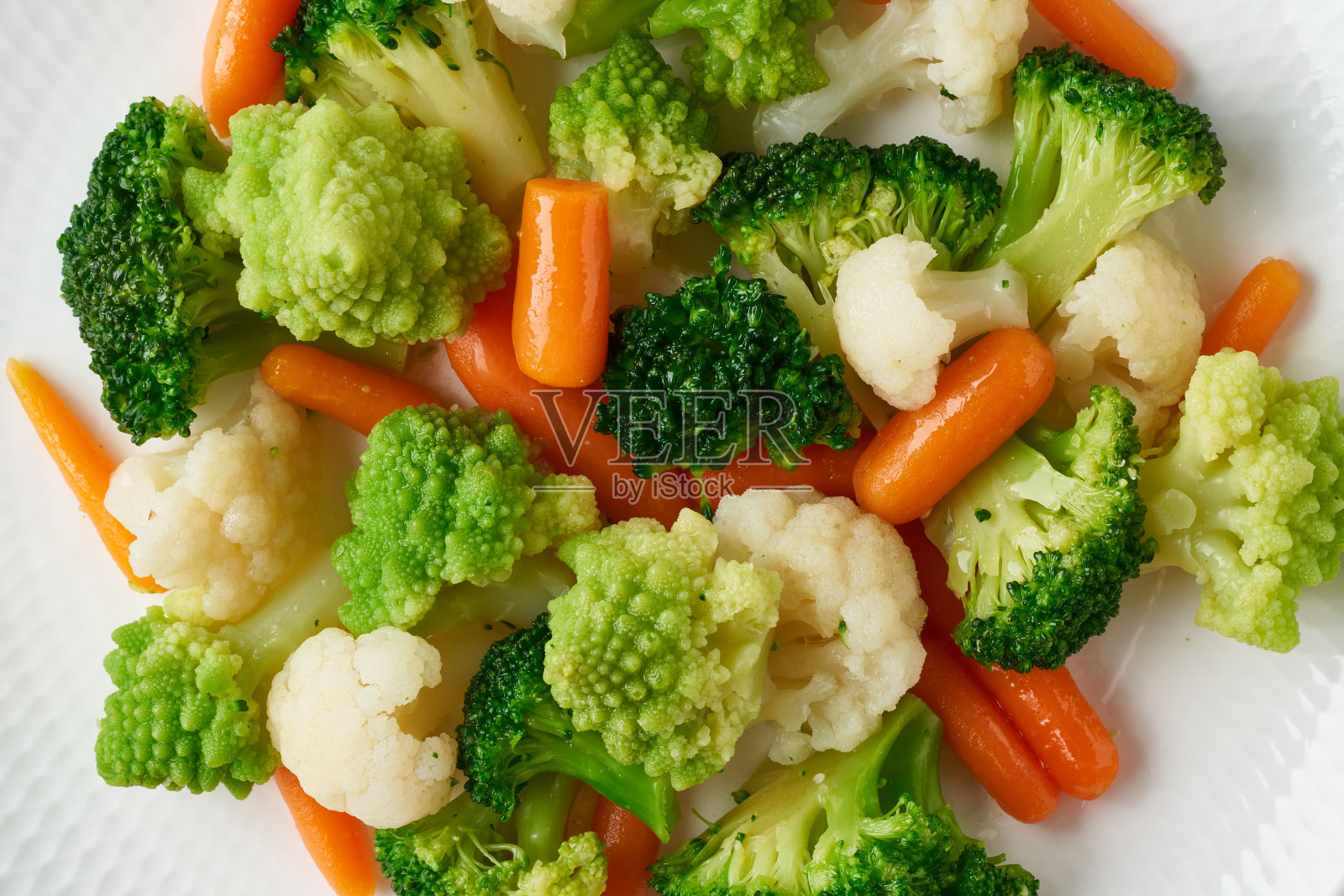 混合煮熟的蔬菜。花椰菜、胡萝卜、花椰菜。低热量的清蒸蔬菜照片摄影图片