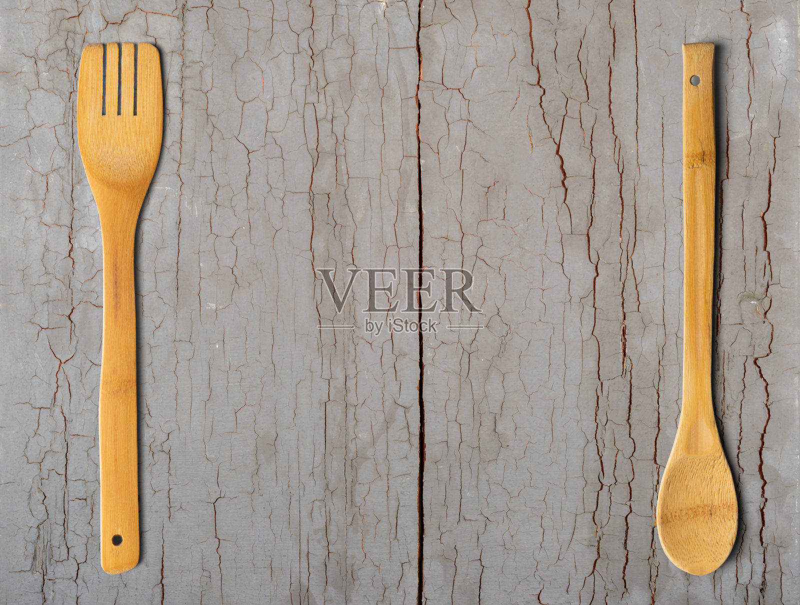 灰色的木桌上放着木勺和木叉。厨房和烹饪概念。照片摄影图片