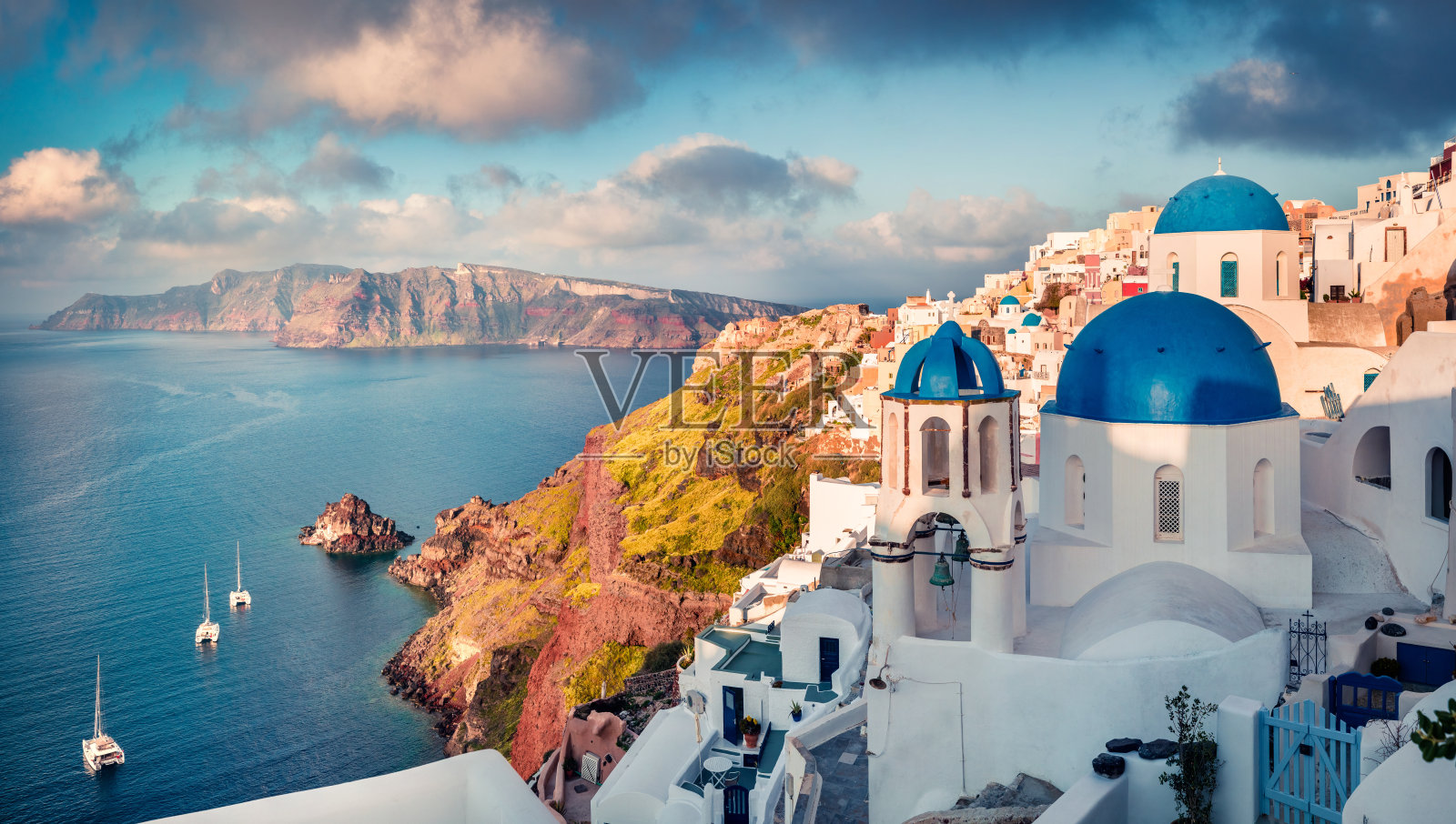 阳光明媚的早晨，圣托里尼岛。风景如画的春天日出在著名的希腊度假胜地伊亚，希腊，欧洲。照片摄影图片