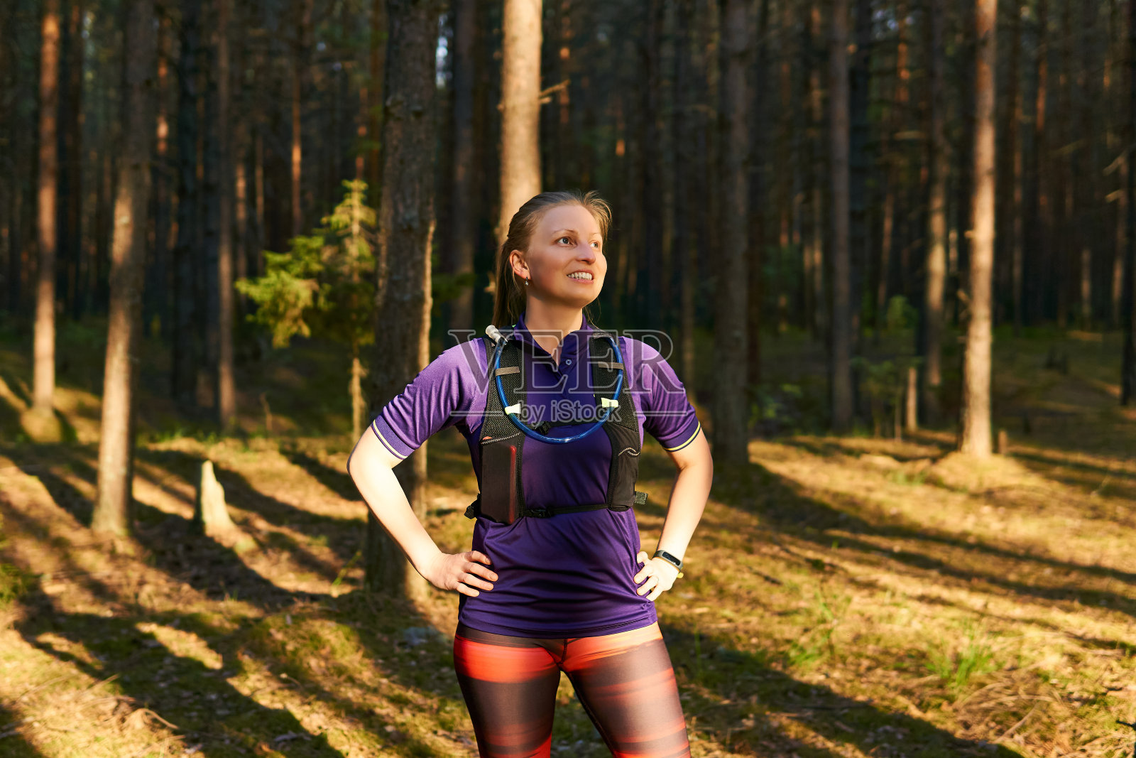 年轻女子跑步者休息之间的慢跑穿过松林照片摄影图片