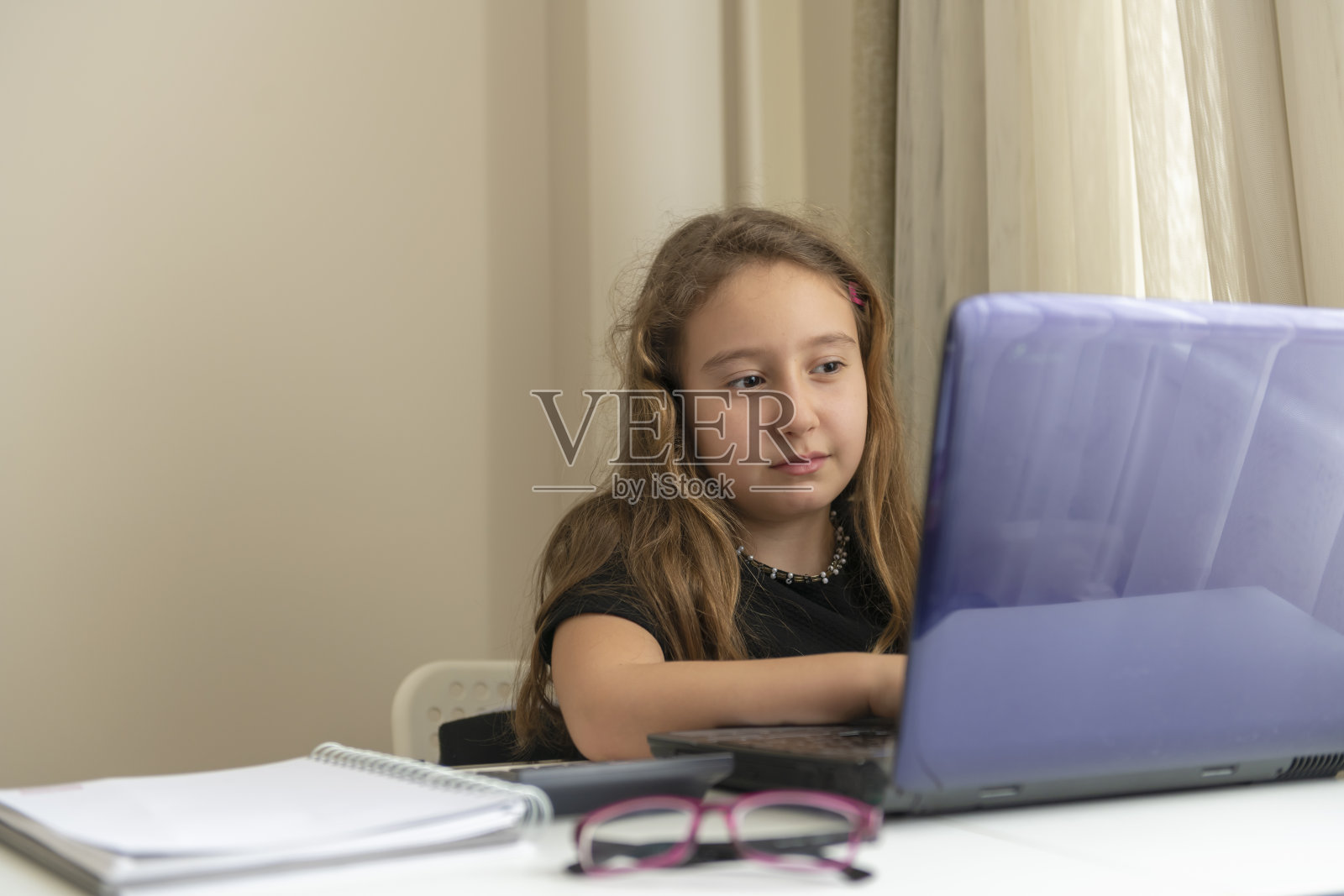 小女孩正在用笔记本电脑在线学习照片摄影图片