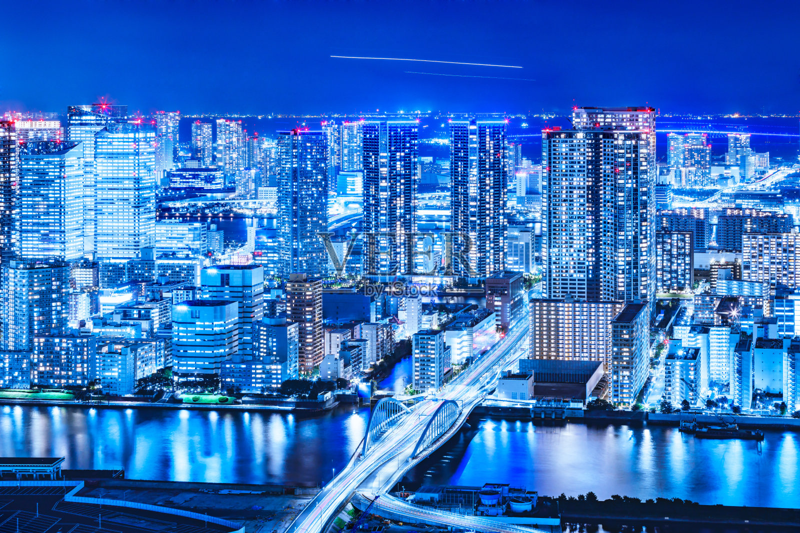 夜景的摩天大楼排列在东京的滨水与耀眼的光照片摄影图片