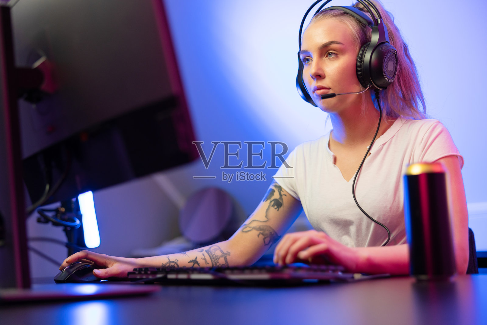 职业玩家女孩戴着耳机在电脑上玩在线多人视频游戏照片摄影图片