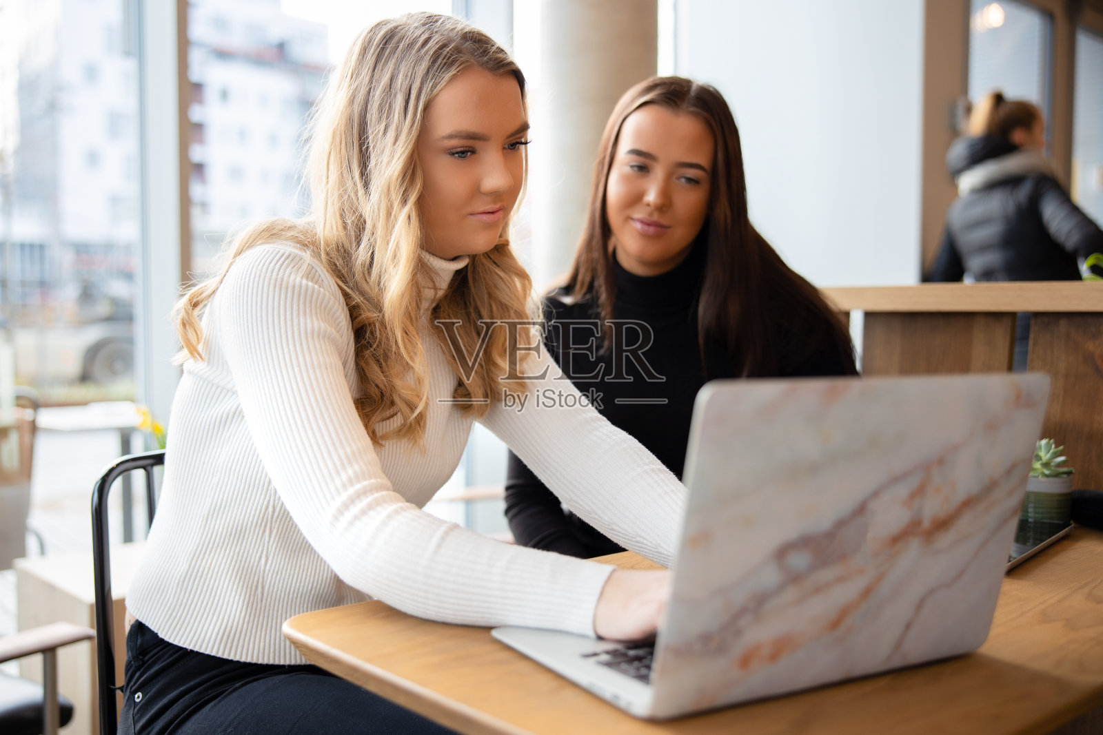 两名女学生在城市的一家咖啡店工作照片摄影图片