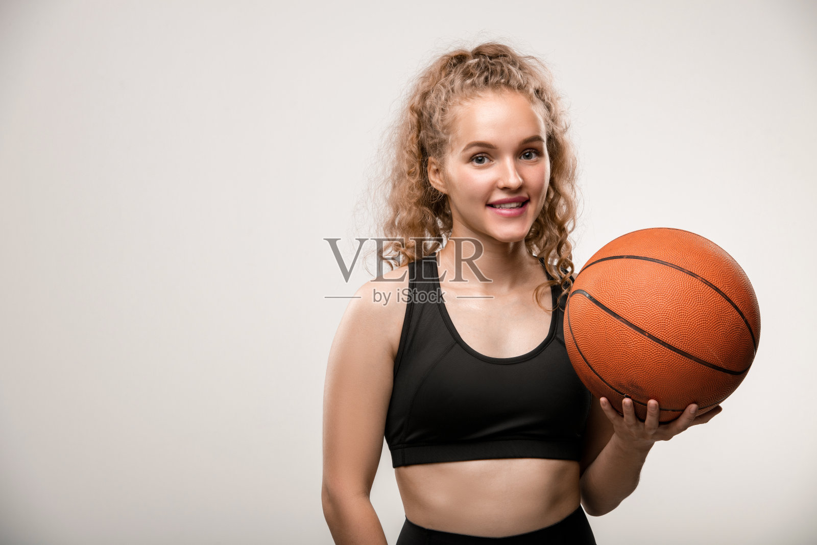 快乐年轻成功的女篮球运动员在黑色运动服拿着球照片摄影图片