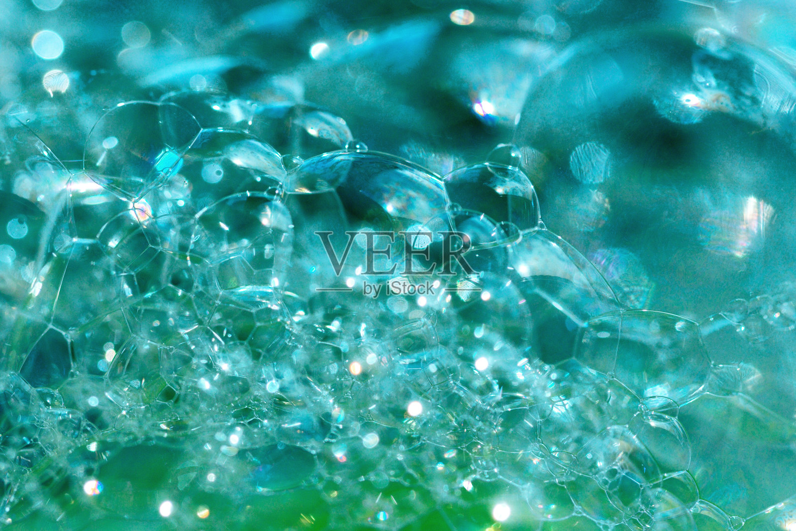 近距离照片的蓝绿色透明的肥皂泡和泡沫。抽象背景，选择性对焦，散焦图像，散焦背景。照片摄影图片