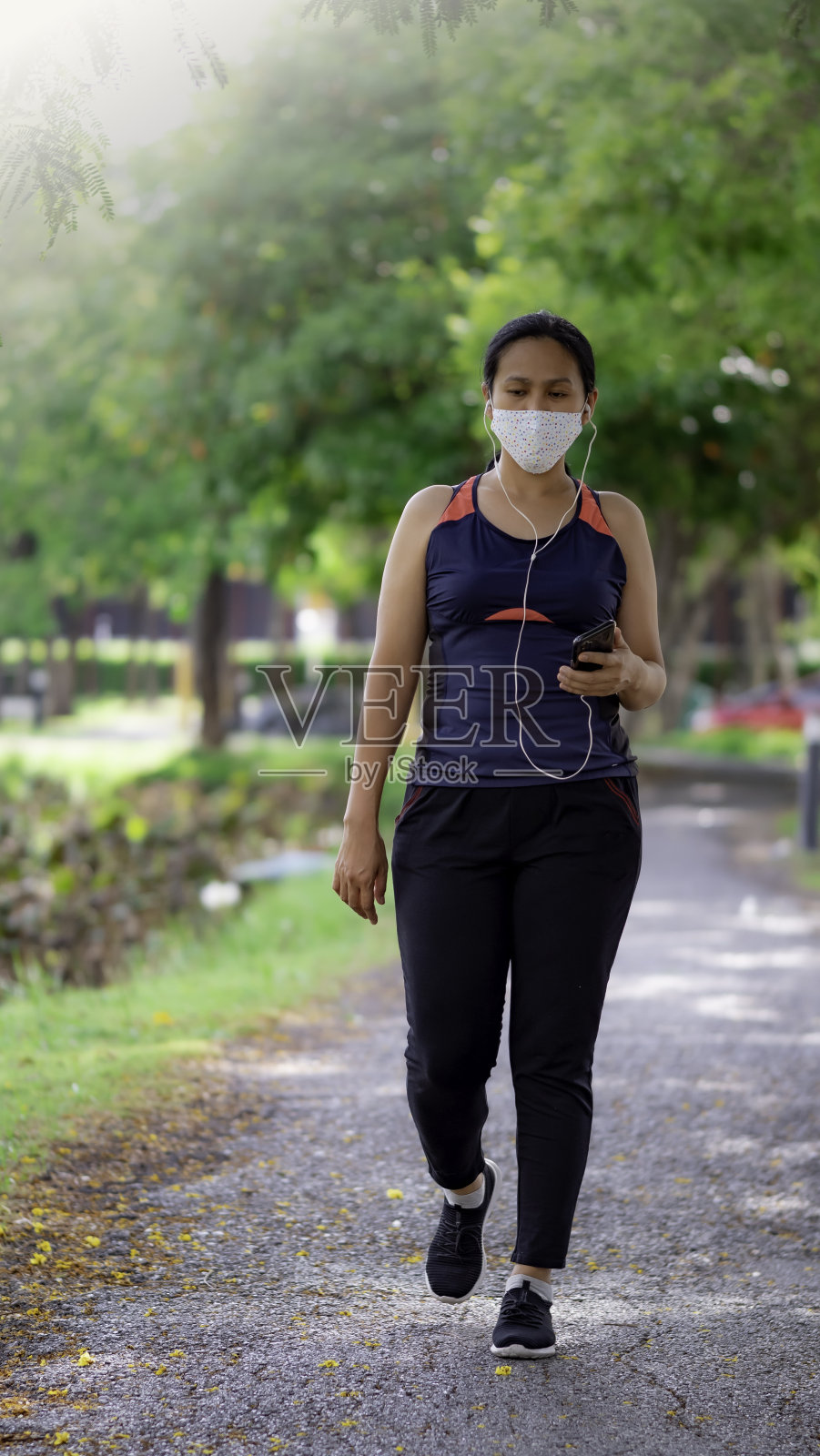 亚洲妇女戴着面具在公园慢跑的肖像照片摄影图片