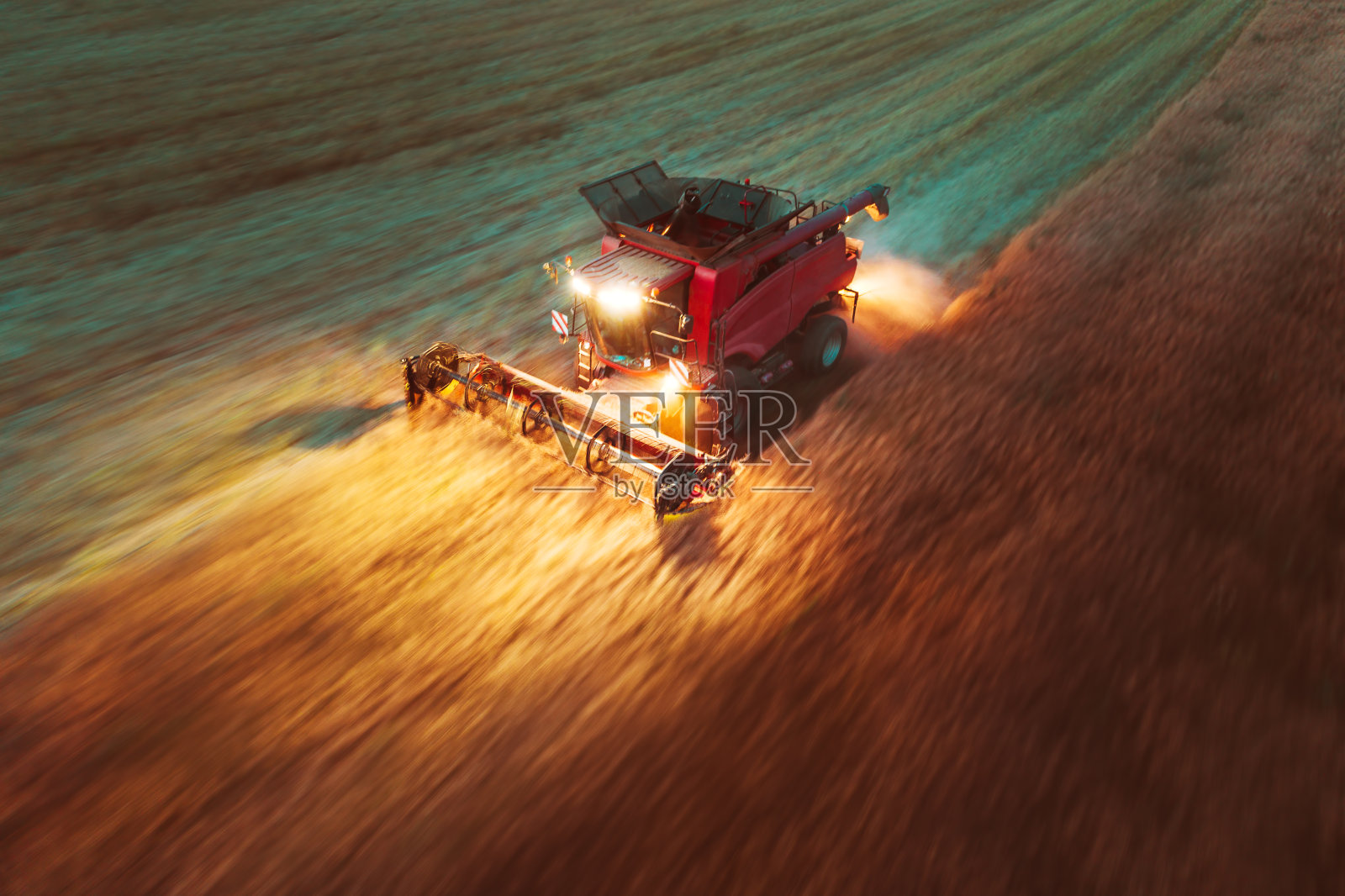 联合收割机收割金灿灿的成熟麦田。照片摄影图片