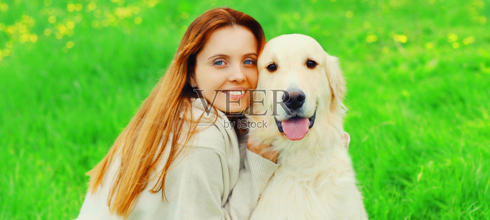 近距离肖像幸福的主人女人与金毛猎犬在绿色的草地上照片摄影图片