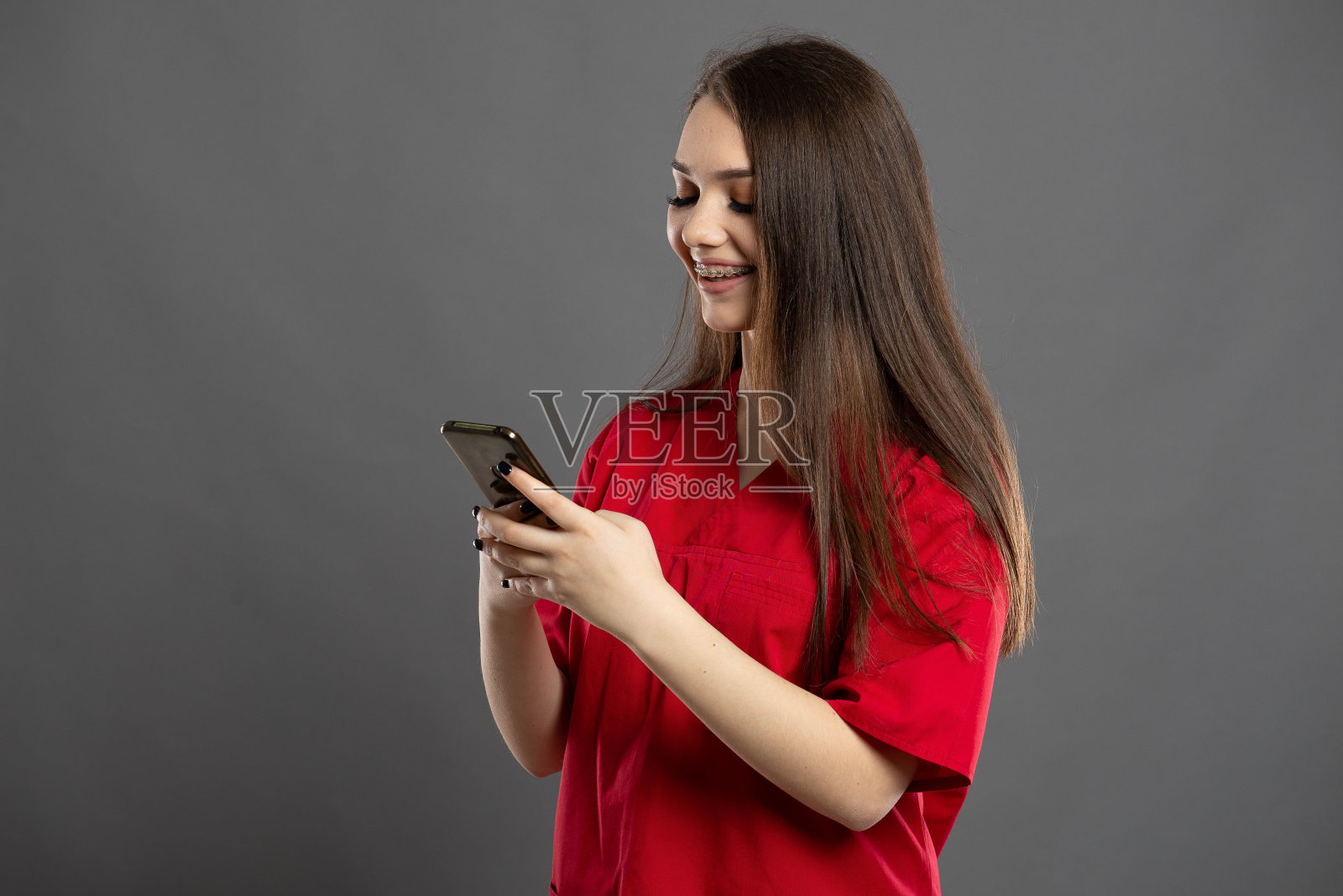 年轻的黑发护士用手机发短信照片摄影图片