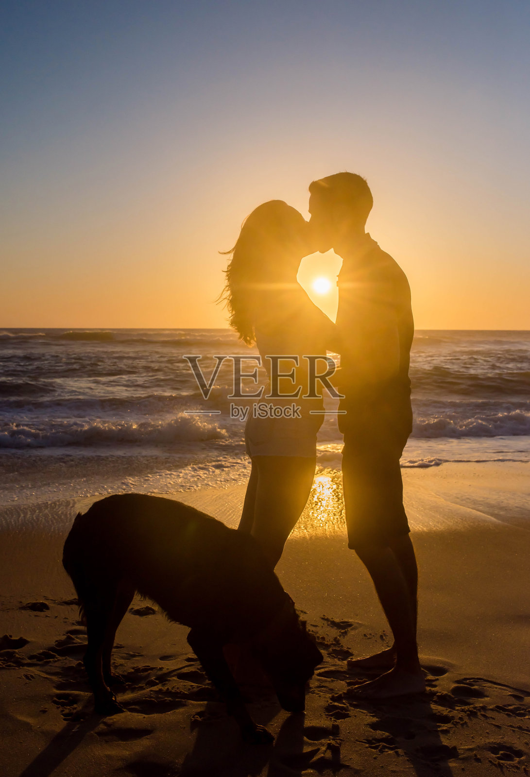 晚上在海滩上，一对相爱的年轻情侣照片摄影图片