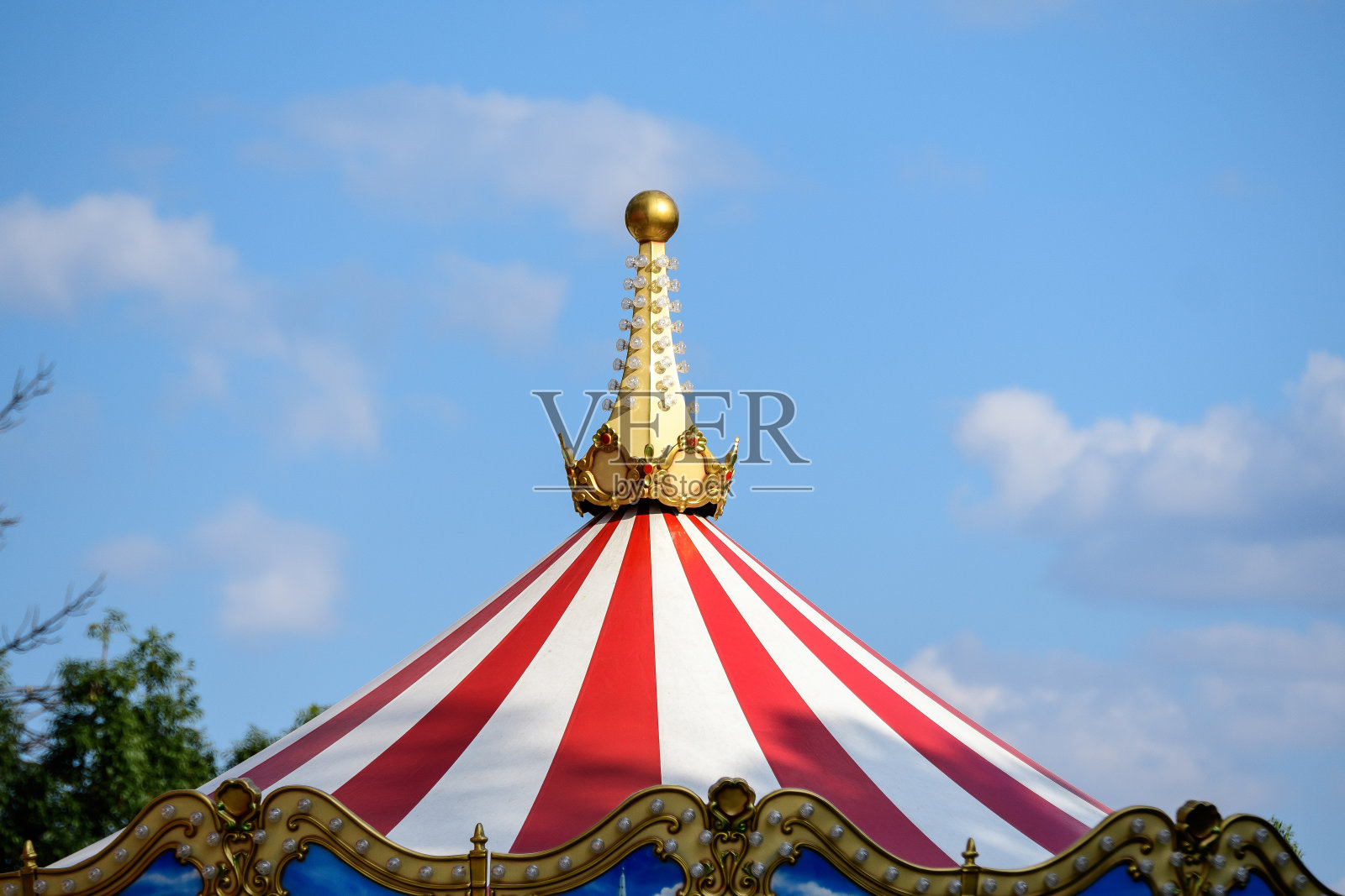在法国巴黎，白色、红色和金色的儿童旋转木马的屋顶朝向湛蓝的天空照片摄影图片