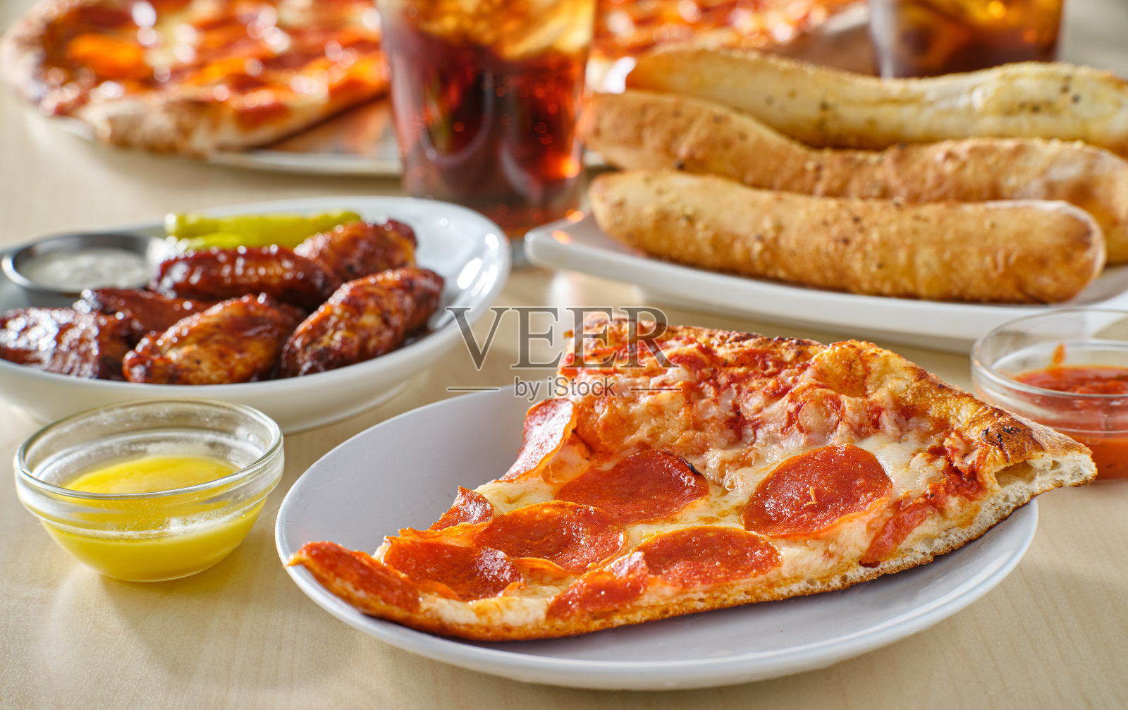 切片的意大利辣香肠披萨和面包棒，照片摄影图片