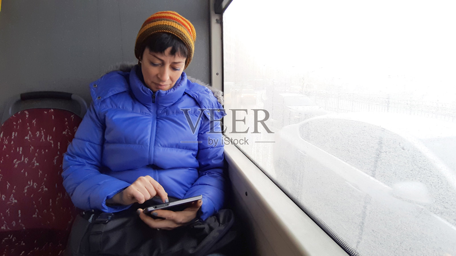 Shot of woman using a digital tablet while traveling on a bus照片摄影图片