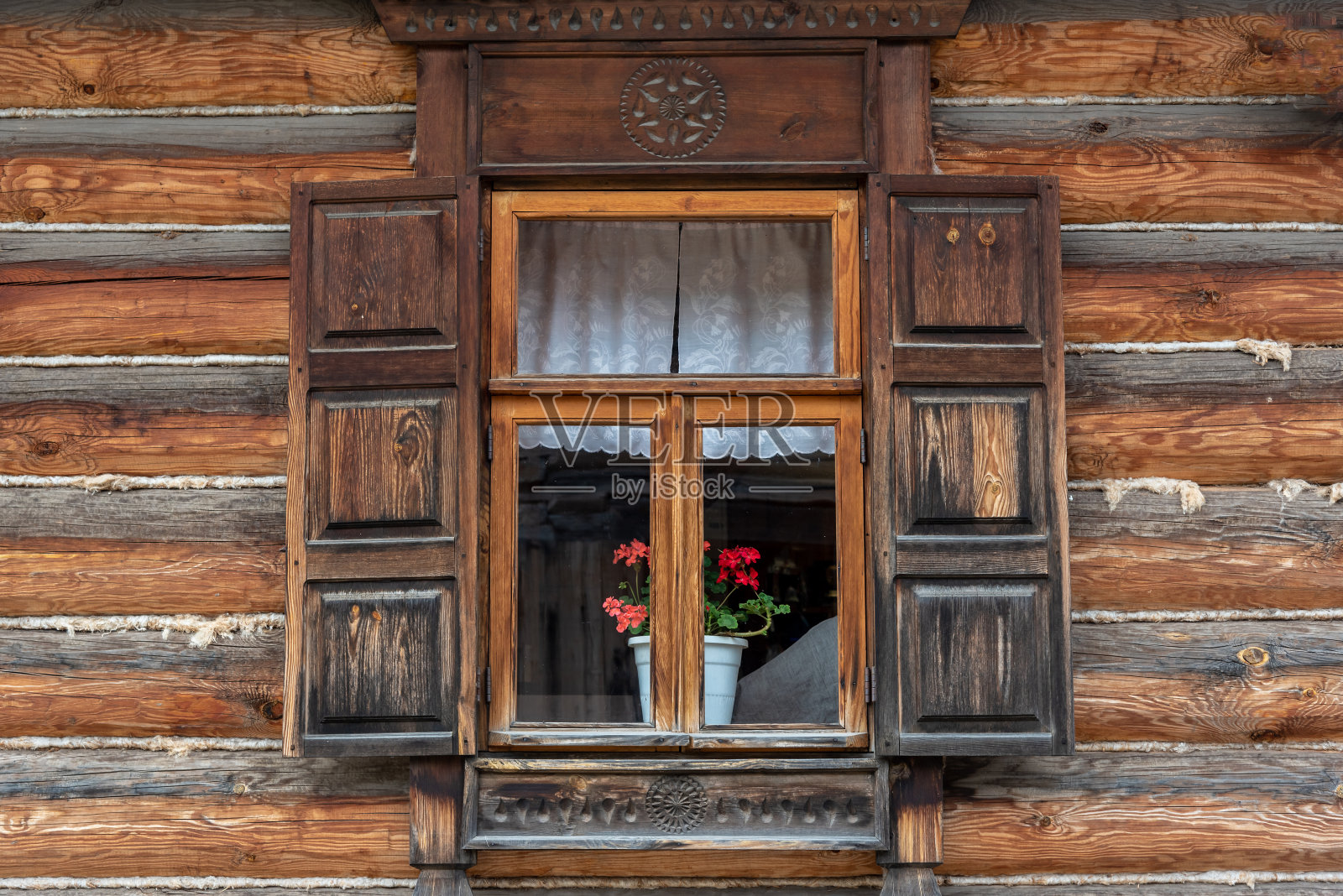 乡村房屋的窗户，木制的碎木片和天竺葵花盆照片摄影图片