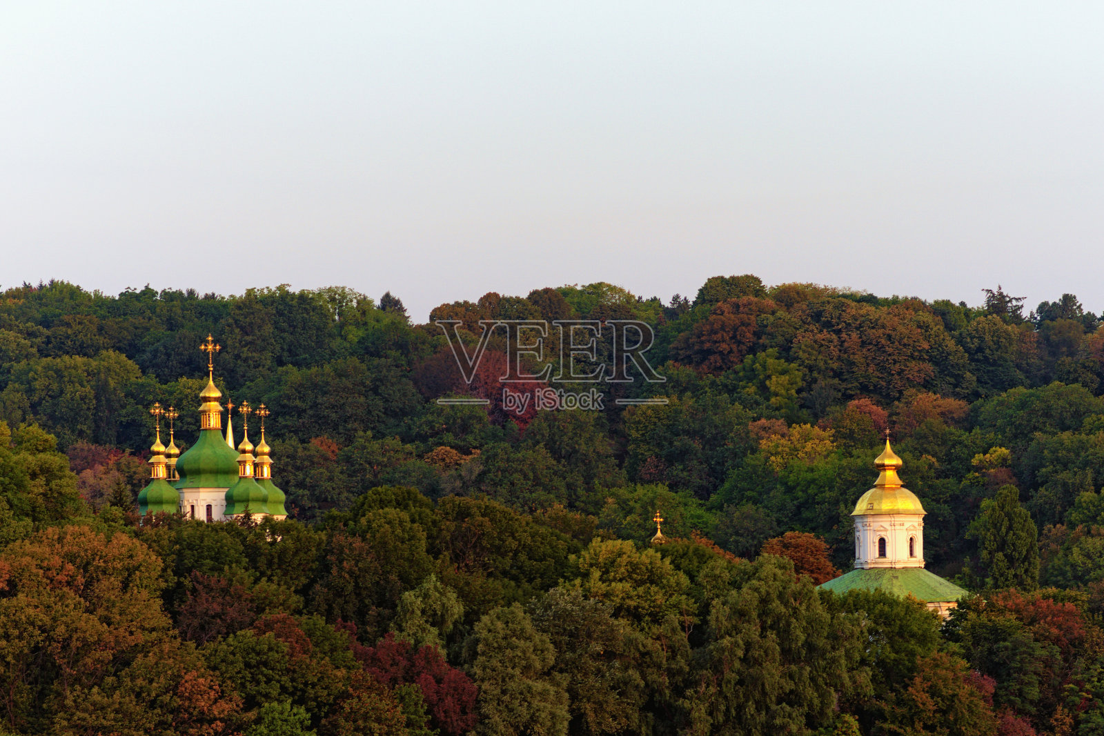 令人惊叹的早晨和秋天景色，基辅著名的山在蓝天的映衬下。圣乔治大教堂和维杜比奇修道院古老的迈克尔大教堂的圆顶在老树之上。基辅照片摄影图片