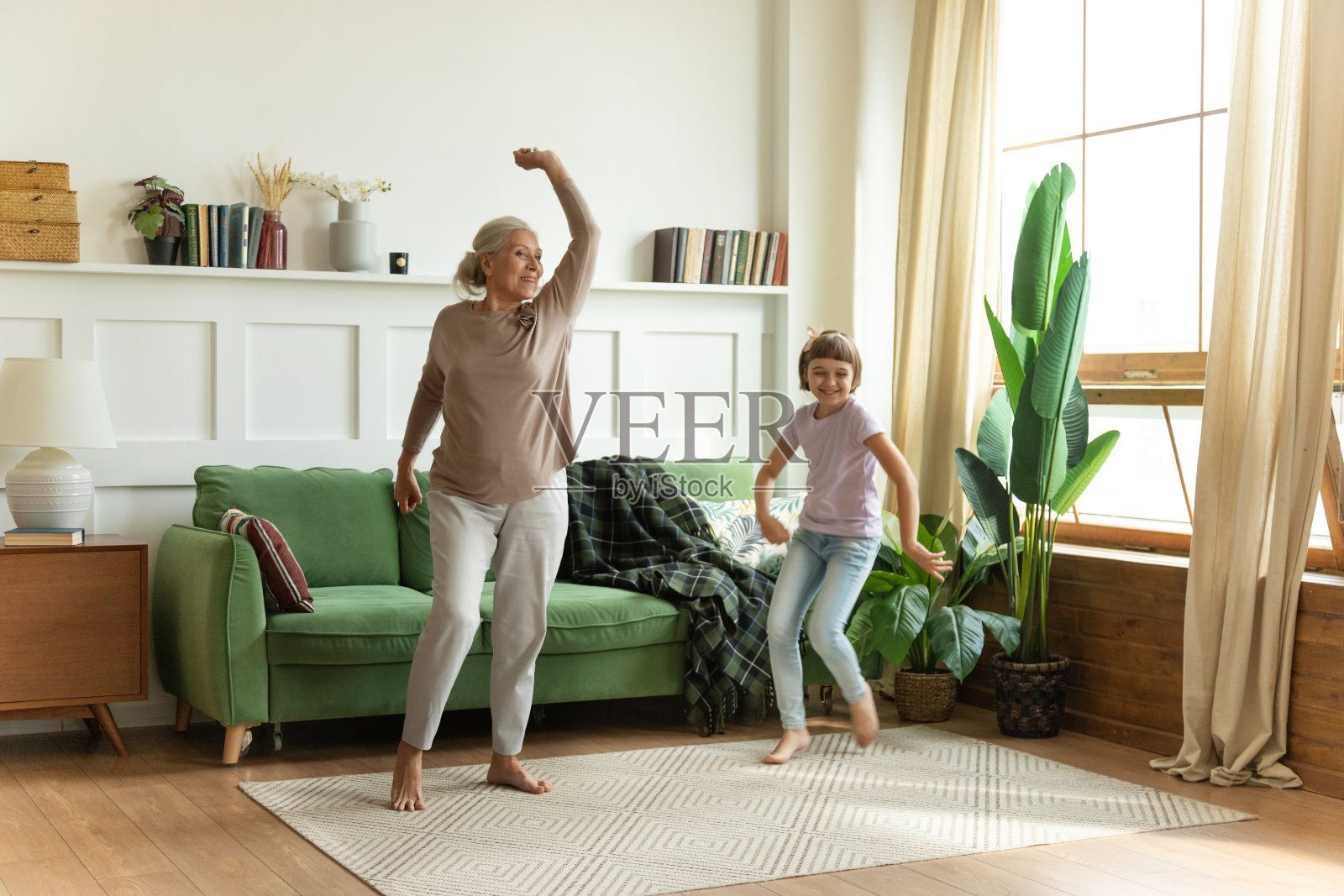 大喜健康的赤脚老奶奶和可爱的小女孩孙女在舒适的家跳舞照片摄影图片