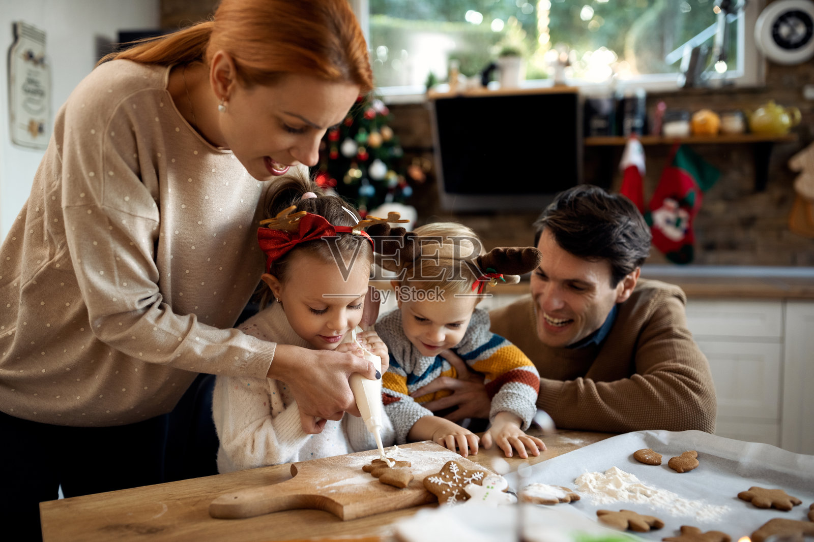 快乐的家庭装饰姜饼饼干，同时准备圣诞假期。照片摄影图片