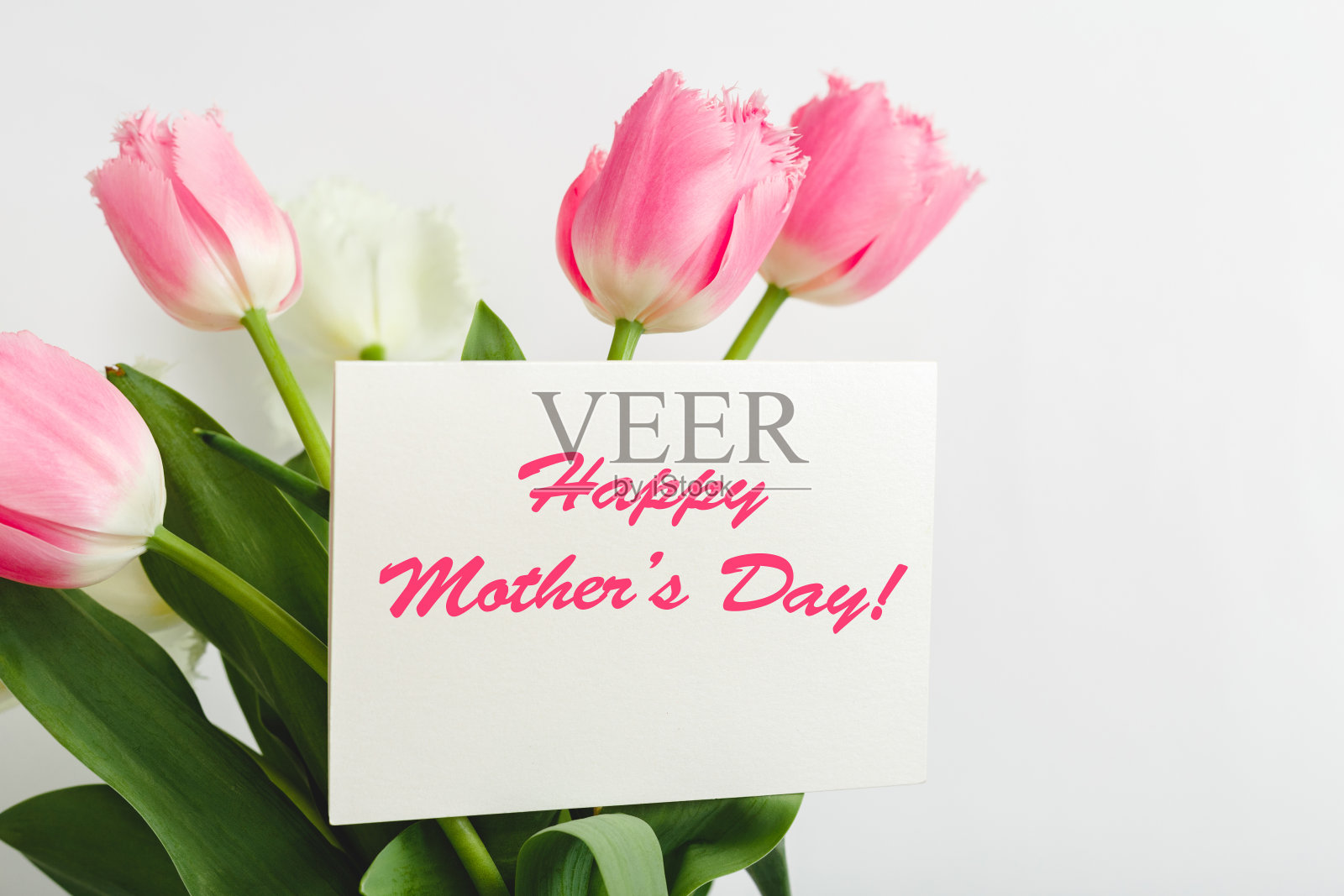 母亲节快乐的文字在礼品卡在白色的背景花束。给妈妈的贺卡。送花，送花贺卡送给女性。粉红色郁金香装饰的贺卡。照片摄影图片