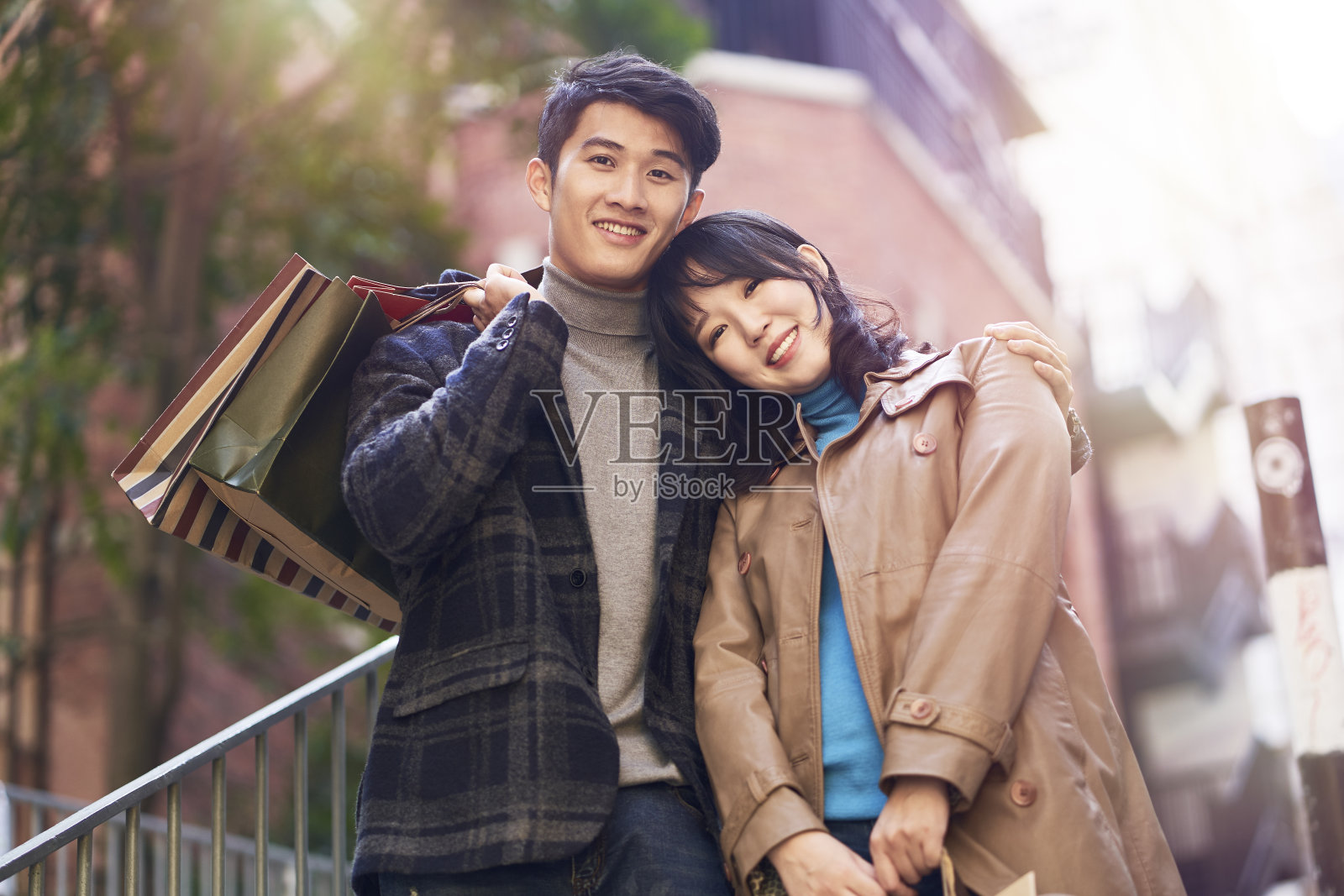 户外肖像年轻的亚洲夫妇与购物袋在手中照片摄影图片