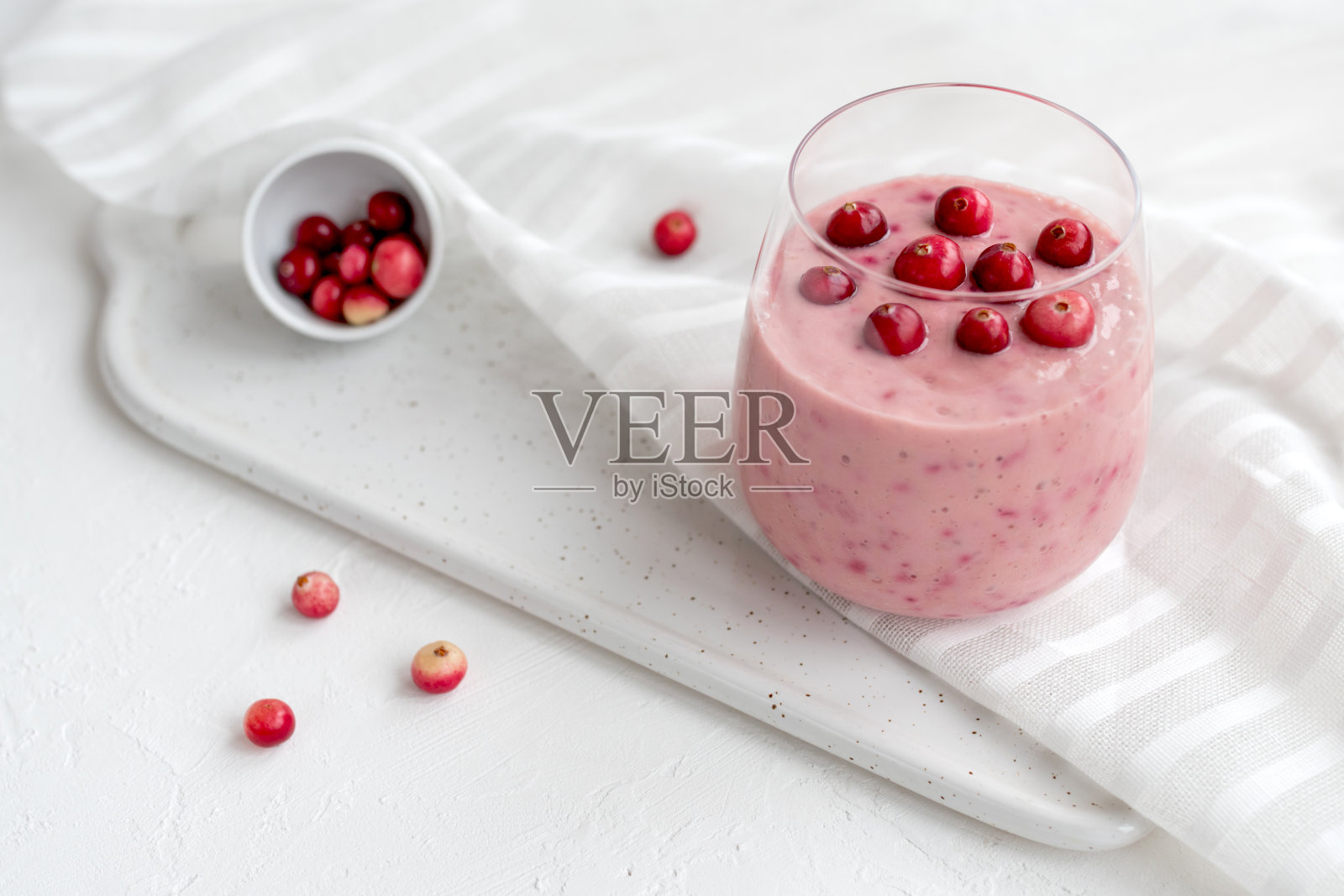 一杯加蔓越莓和椰奶的冰沙照片摄影图片