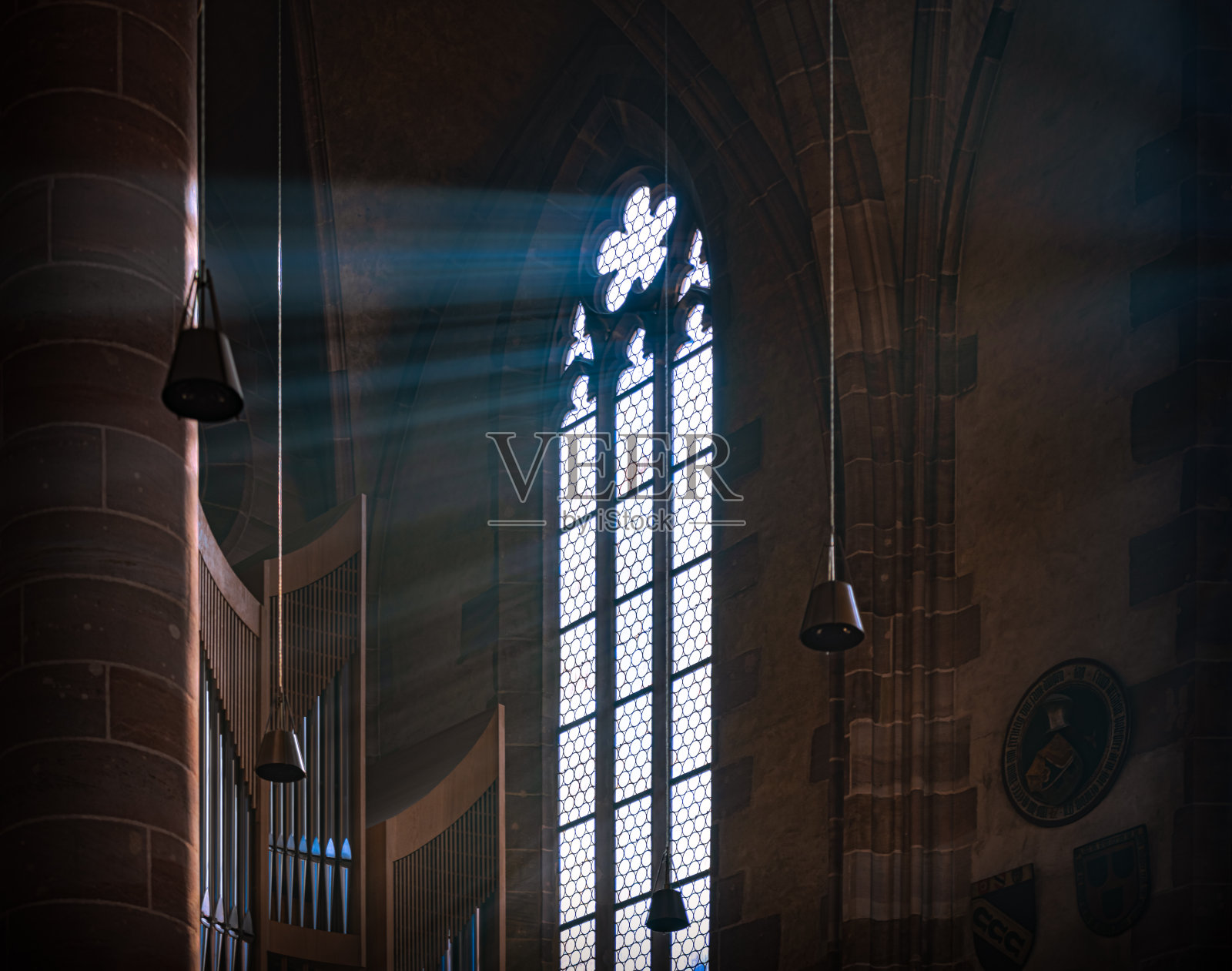 在德国巴伐利亚的纽伦堡大教堂，阳光透过古老的彩色玻璃窗照射进来。照片摄影图片