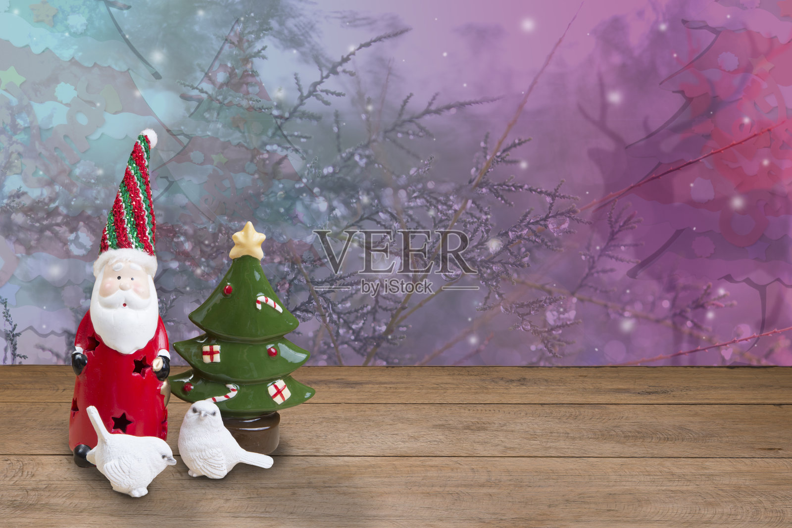 陶瓷圣诞老人和两只小白鸟在木地板上和圣诞树。照片摄影图片