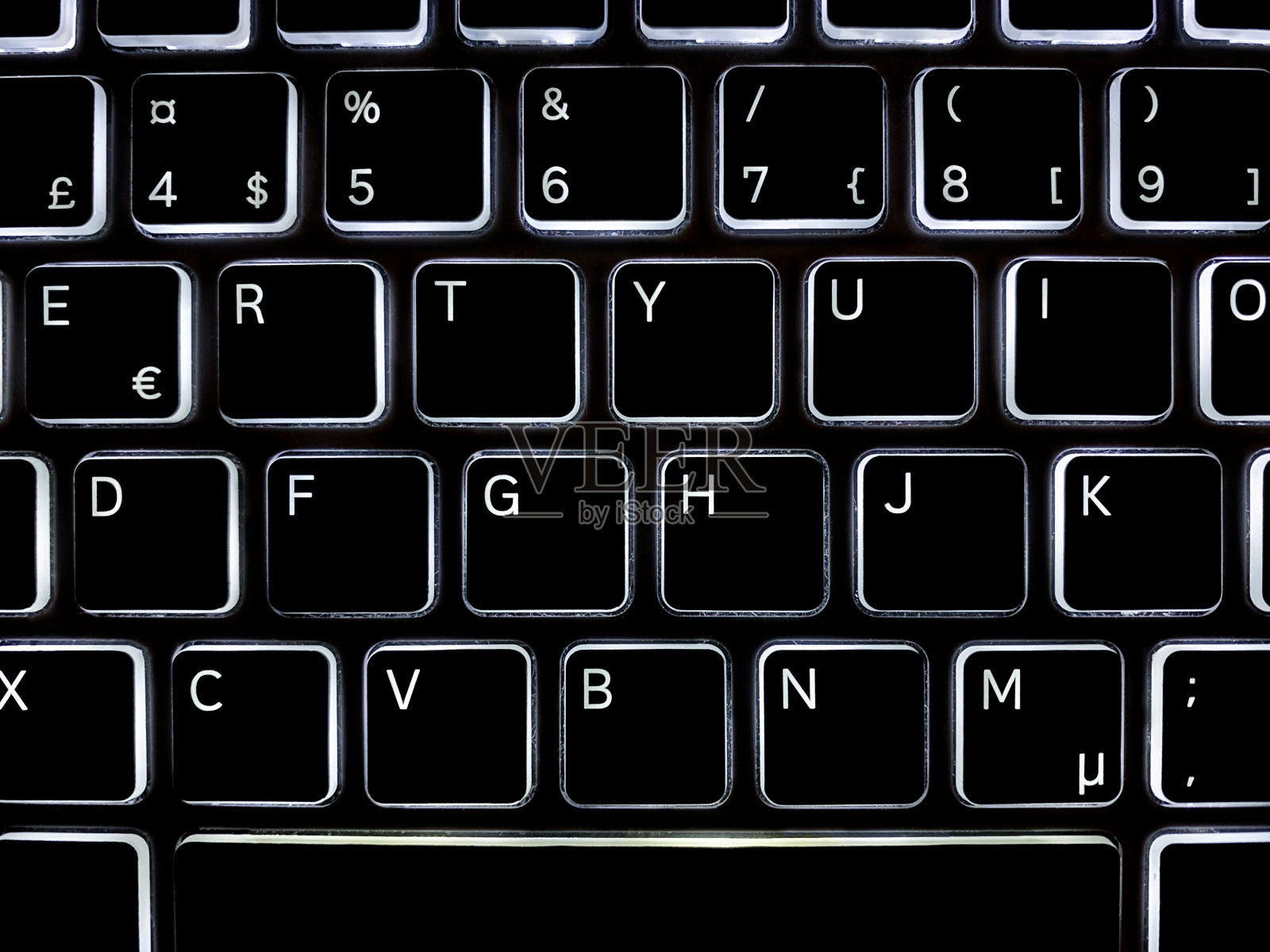 特写俯视图上方黑色发光电脑键盘与白色字母。照片摄影图片