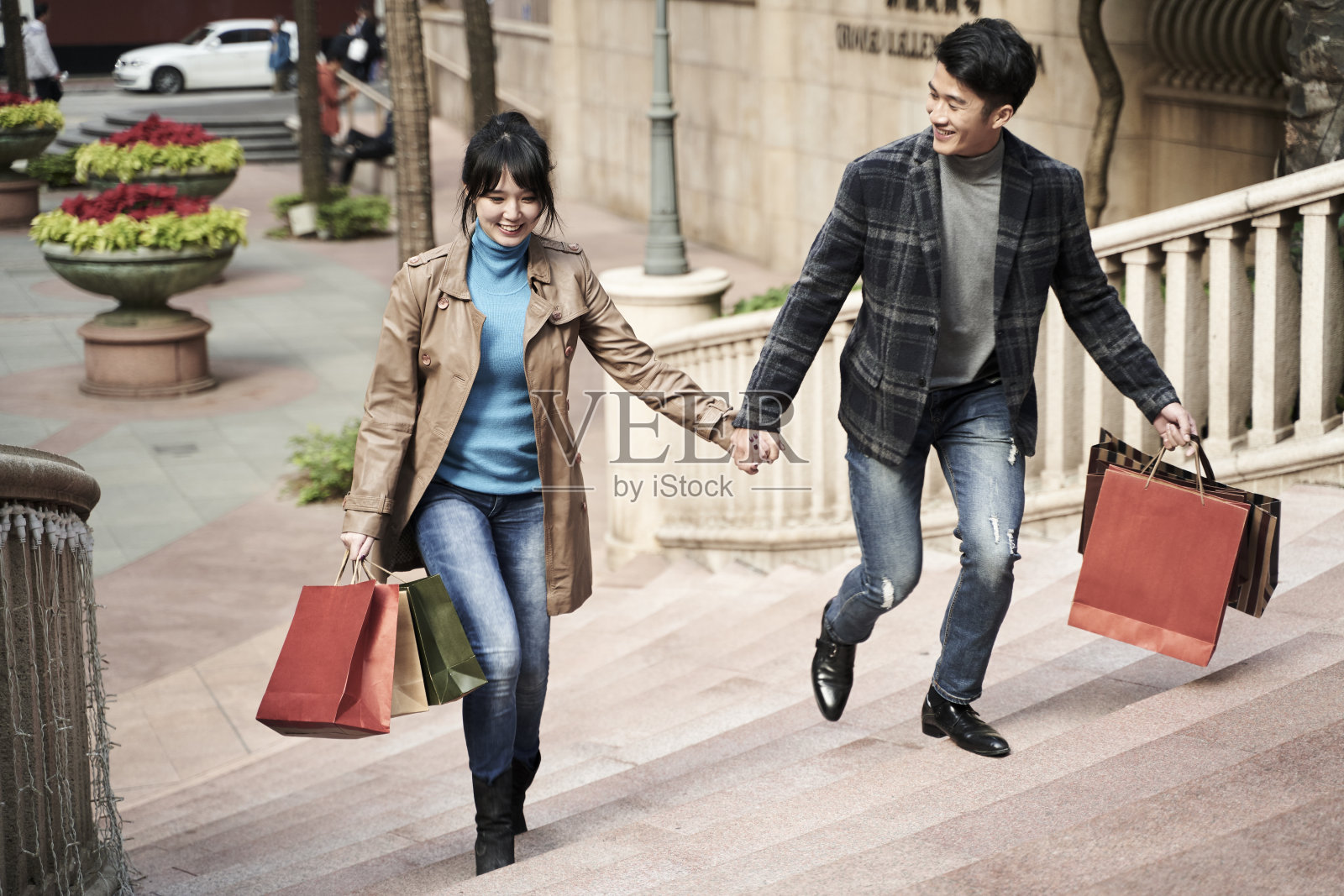 年轻的亚洲夫妇手里拿着购物袋走着照片摄影图片