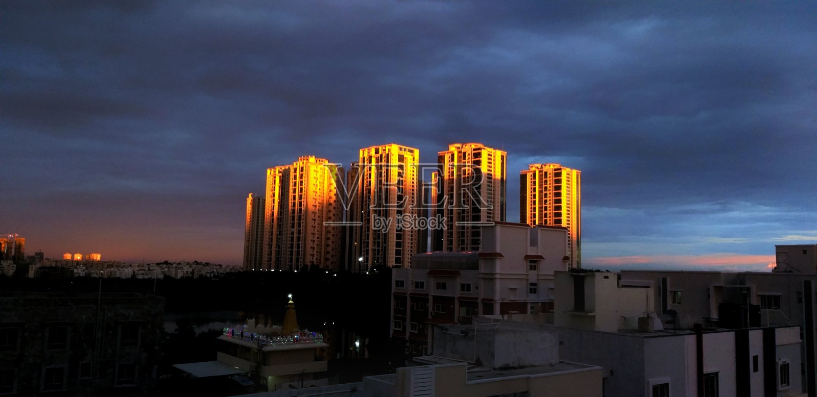 日落时分，夕阳西下，在一座高层建筑上反射出淡黄色的光线。照片摄影图片