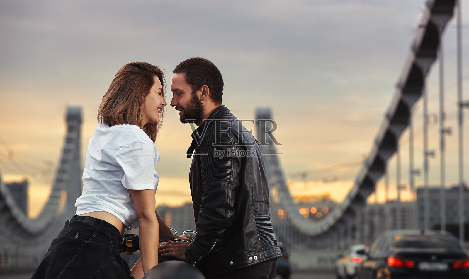 爱情和浪漫的概念。漂亮的一对骑着摩托车对面站在马路中间的桥上，上双固照片摄影图片