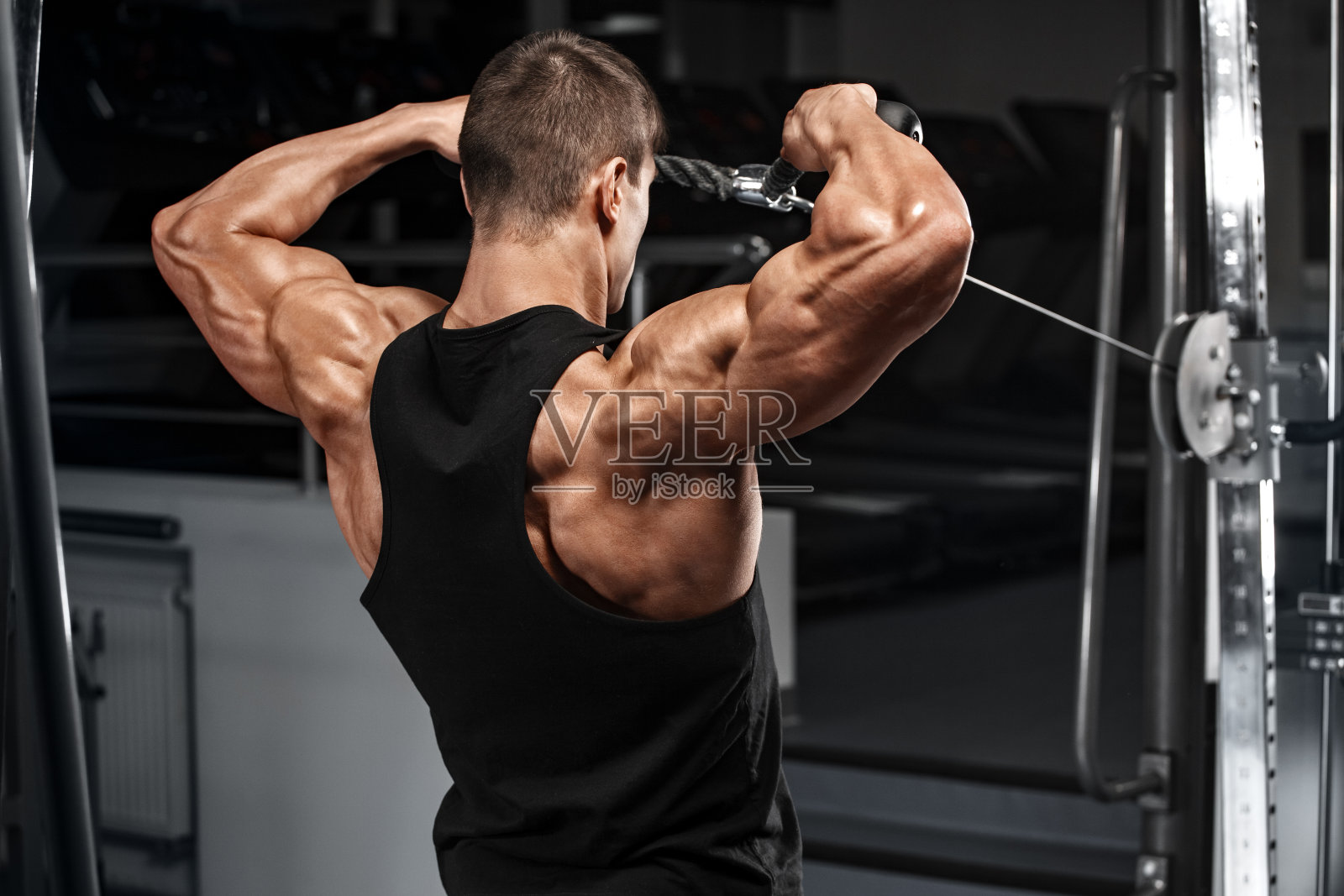 肌肉男在健身房做三角洲运动，强壮的男性照片摄影图片