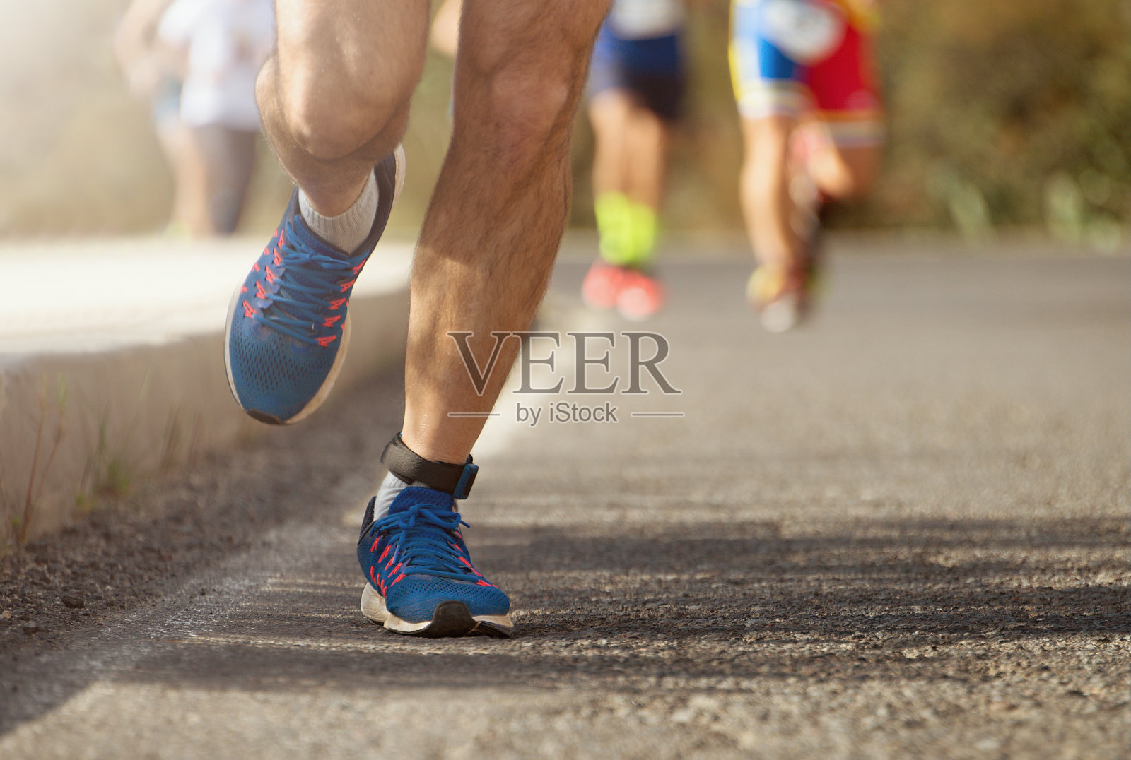 马拉松赛跑，跑步者的脚在路上照片摄影图片