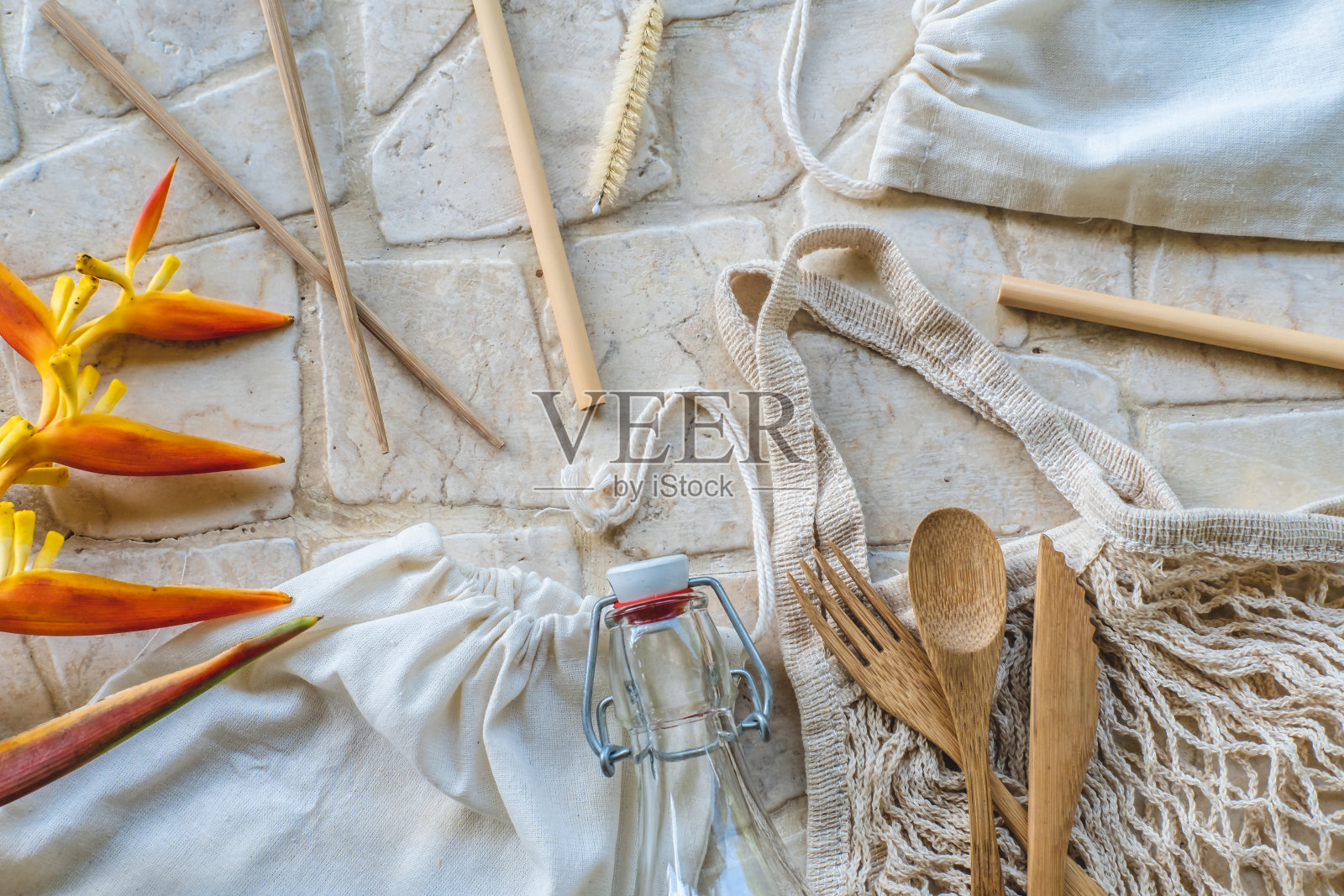 可重复使用的环保厨房产品在石材背景:木制餐具套装，筷子，竹吸管，玻璃填充瓶，纸，网眼棉袋。零浪费和可持续的无塑料生活方式照片摄影图片