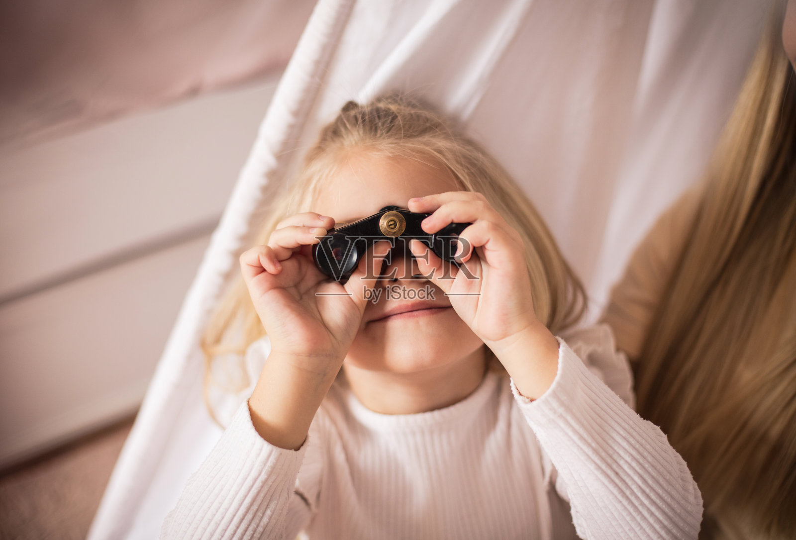 小女孩用望远镜。照片摄影图片