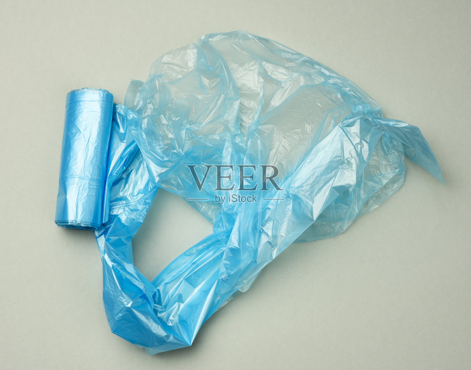 扭曲的蓝色塑料袋垃圾箱在灰色的背景照片摄影图片
